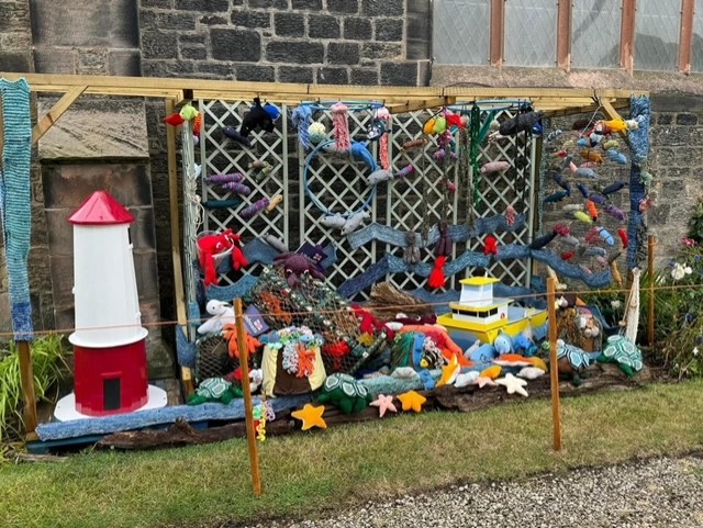 Knitted display depicting life in the sea and water outside St John's church Spittal to celebrate Sea Sunday