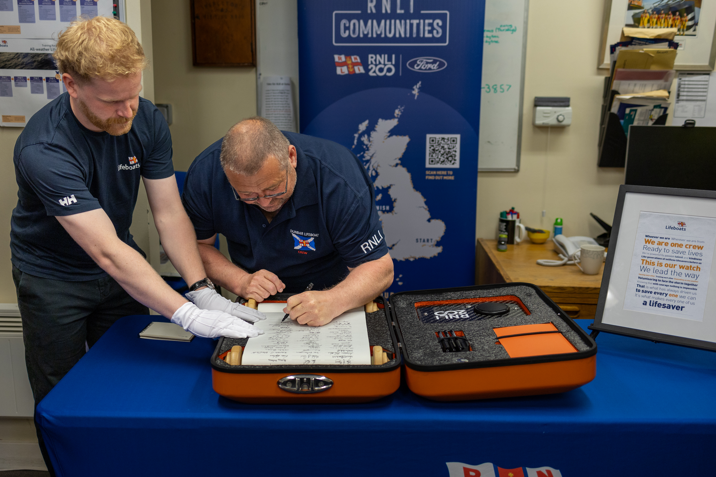 Two men, one signing scroll