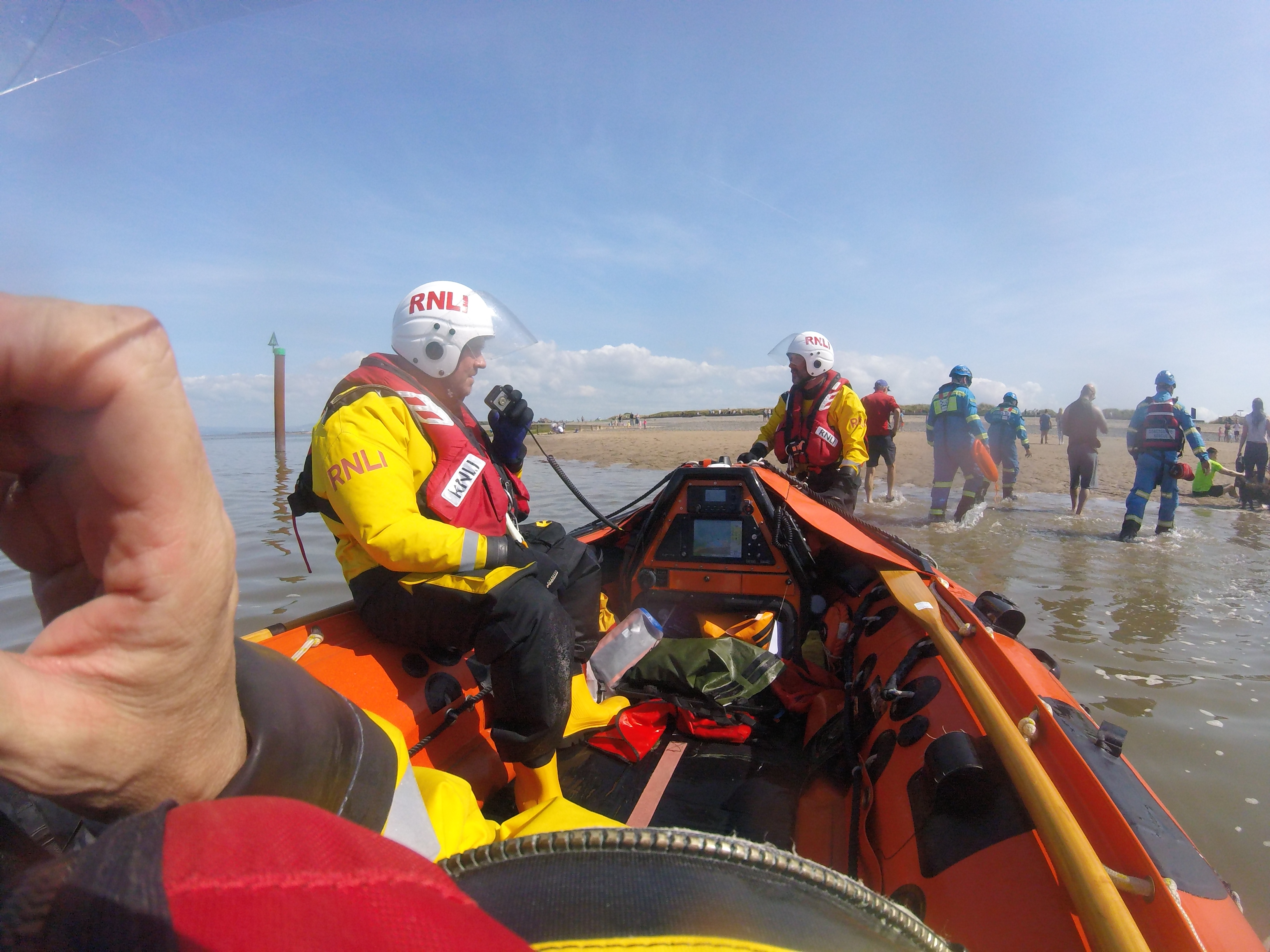 Coastguard and casualties on the beach, having been returned to shore.