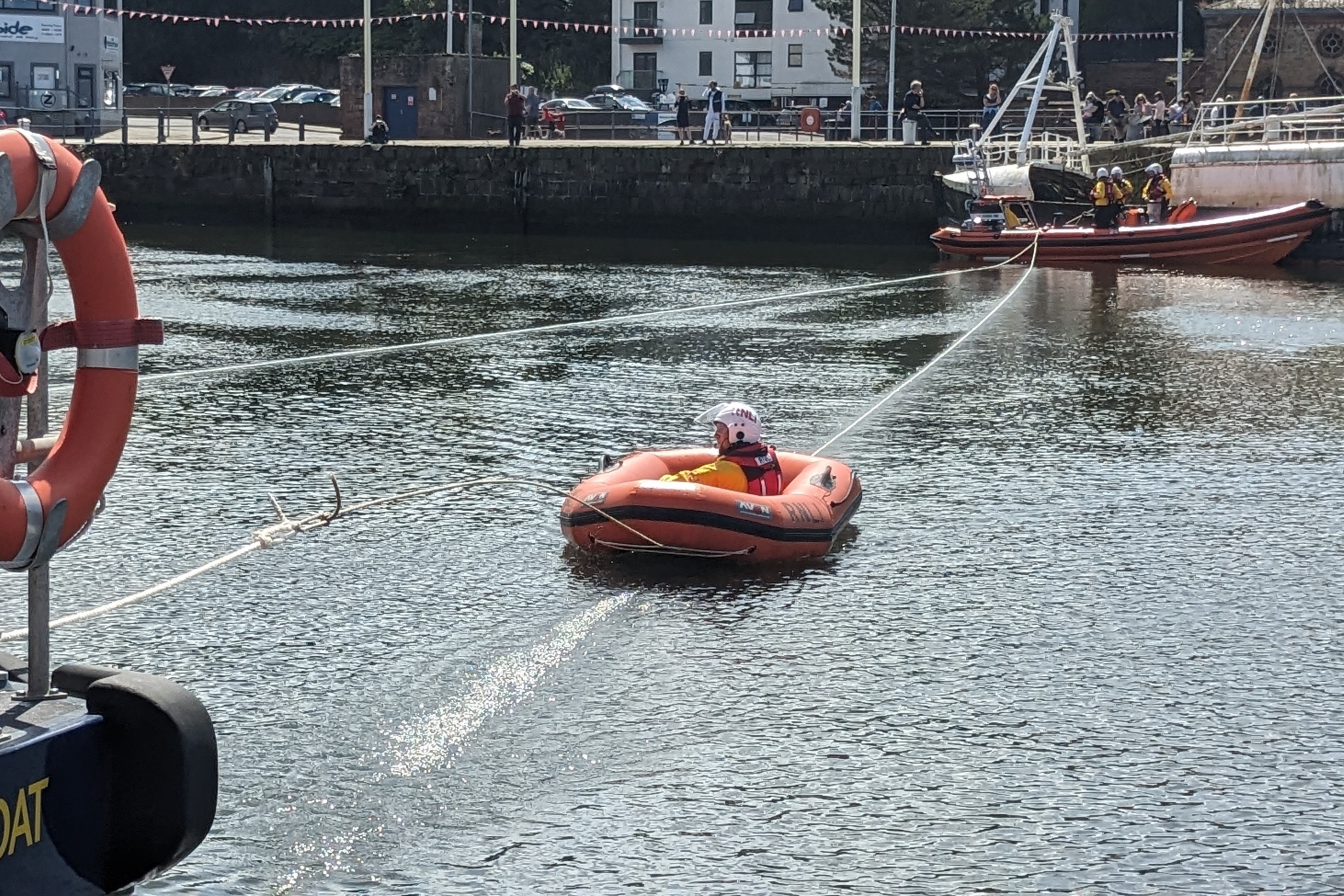 Volunteres from St Bees RNLI being pulled over the water from a fishing boat to Workington RNLI Shannon demonstrating a manoeuvre called Breaches Buoy