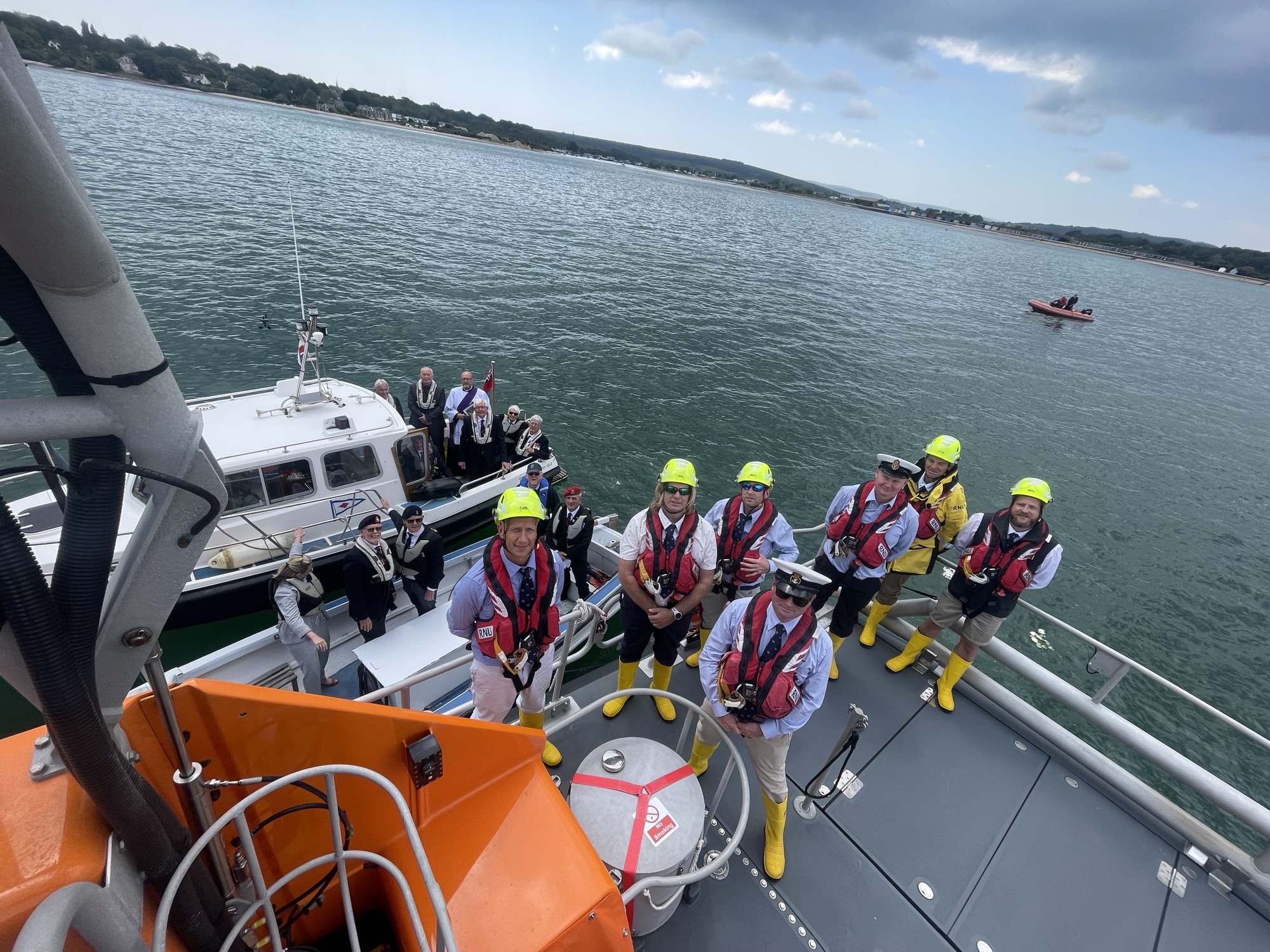 Birds-eye view of the crew and a smaller boat along-side, group photo 