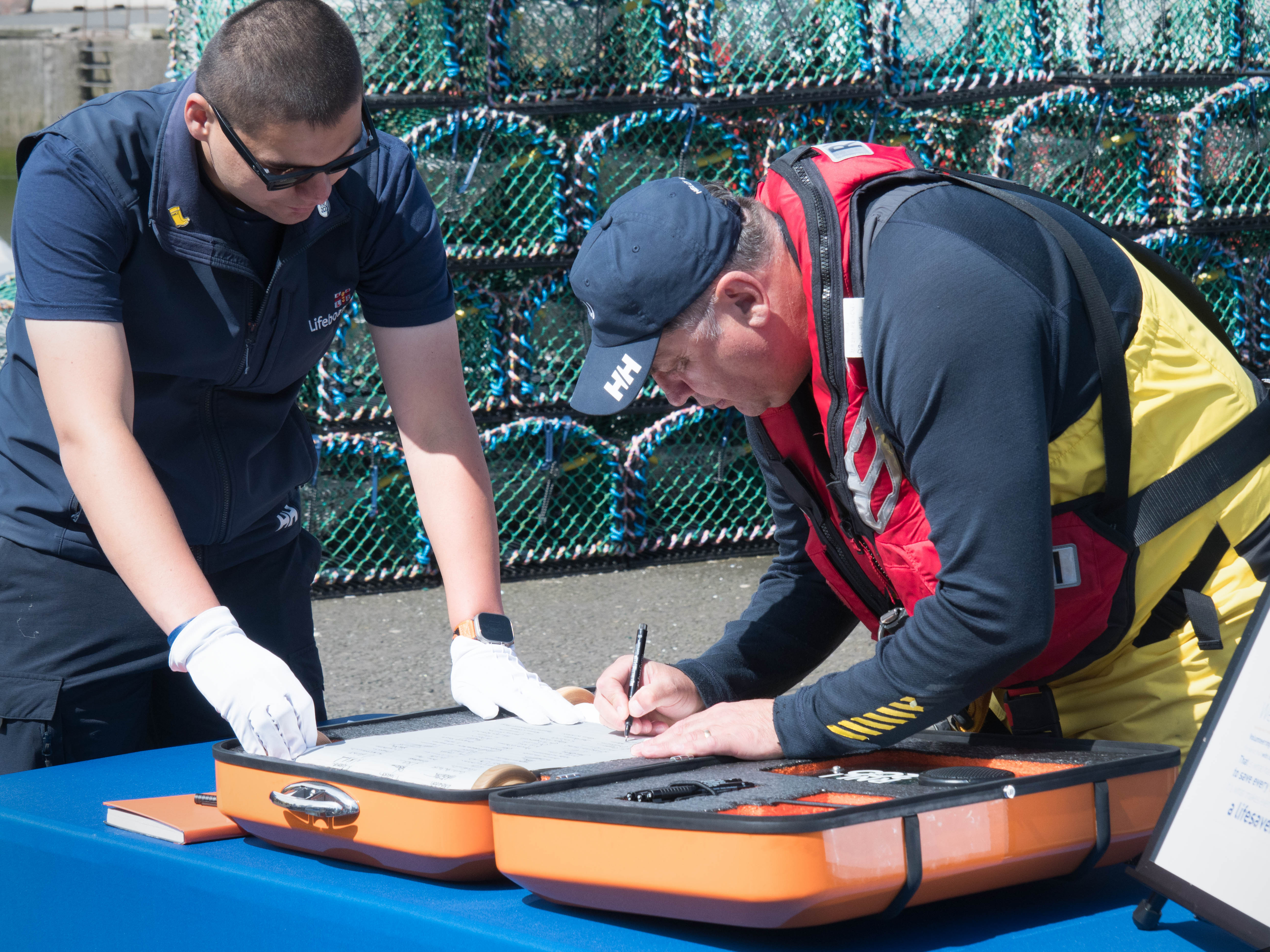 Peter Walker, of Eyemouth RNLI crew, signs the 'Connecting our Communities' scroll