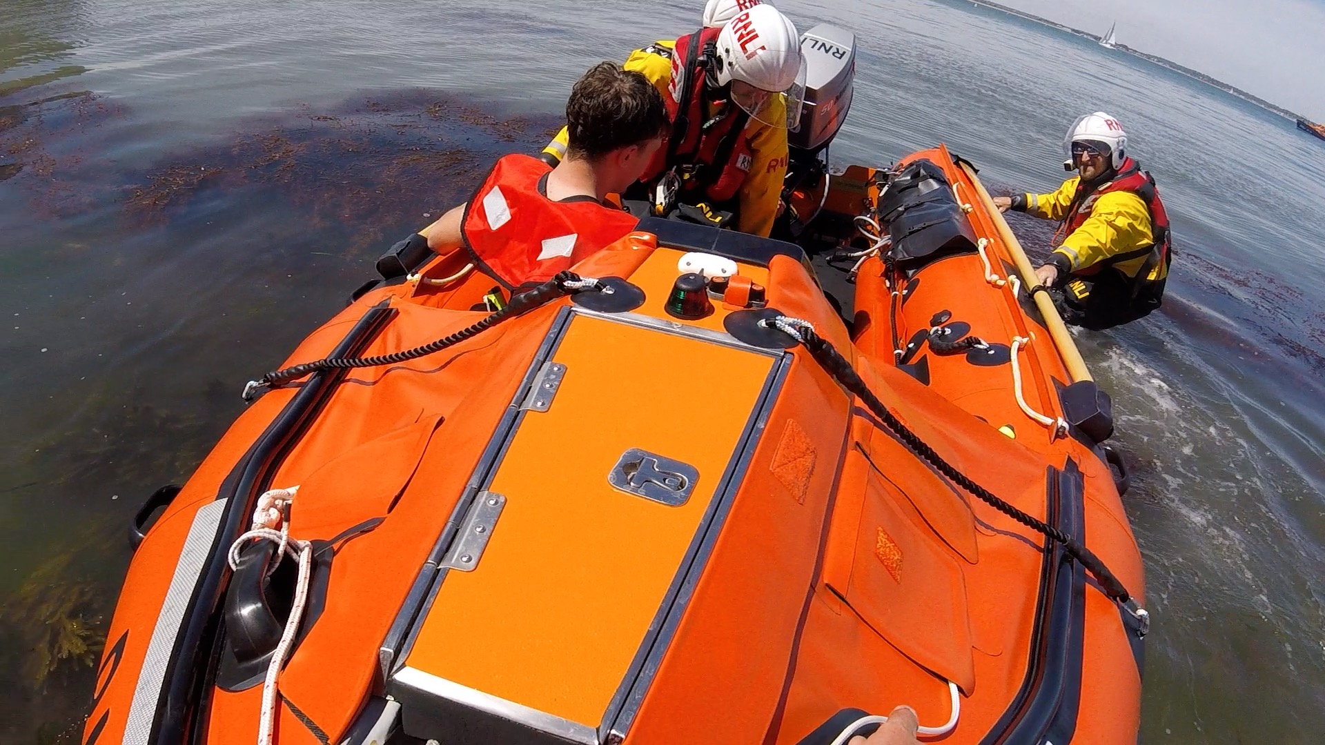 Casualty being transported from Old Harry Rocks on the inshore lifeboat, heading to the all-weather lifeboat that is in the background