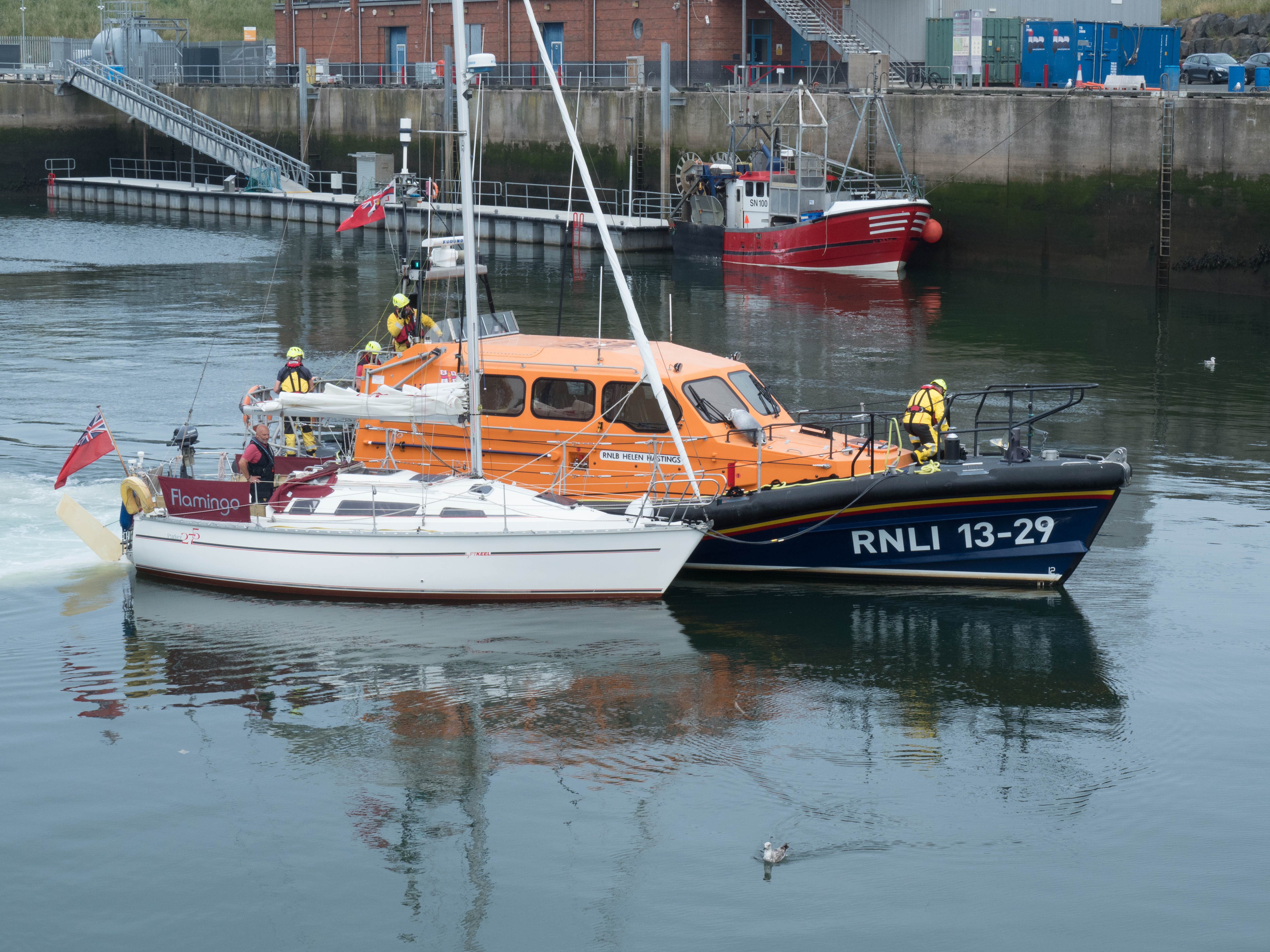 Eyemouth Shannon class all-weather lifeboat tows casualty yacht 'Flamingo' into Eyemouth harbour