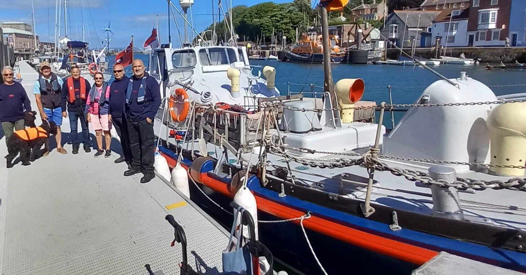 Southend volunteer crew meet Gallichan owners Mike and Carol in Weymouth harbour with Gallichan and Weymouth RNLI Severn class lifeboat in the background