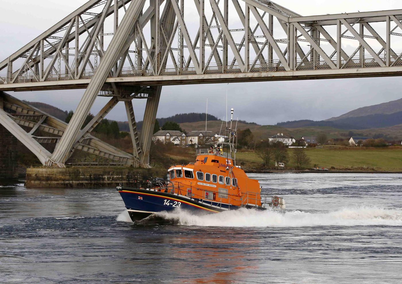 The Trent class lifeboat passes underneath the Connel Bridge at Connel near Oban