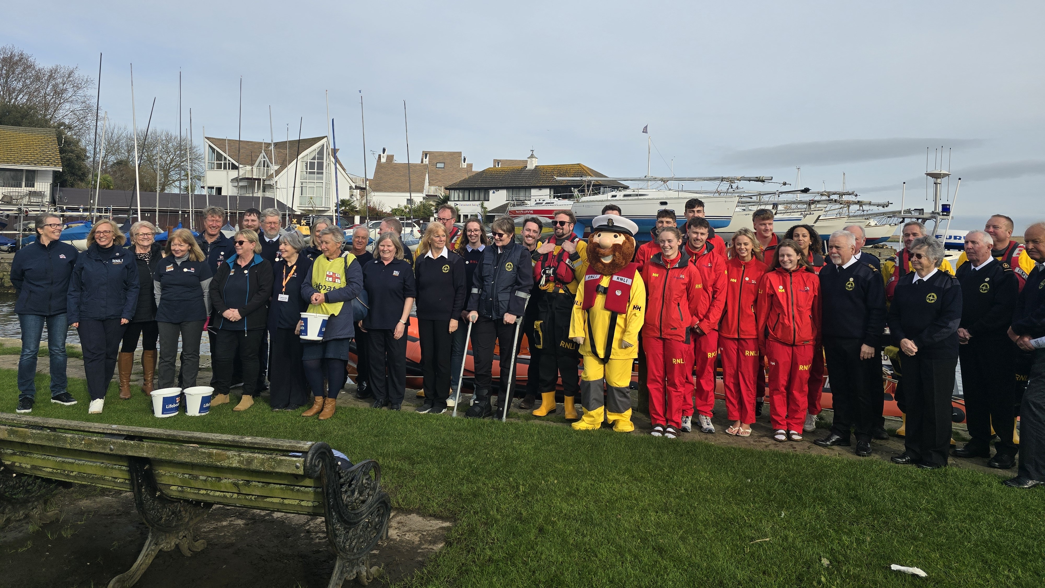 A group of Mudeford RNLI fundraising crew, East Dorset lifeguards and members of the National Coastwatch Institute with the RNLI's Stormy Stan at at Christchurch Quay