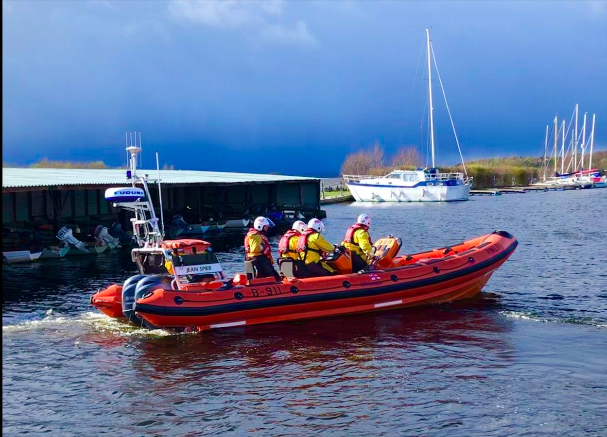 Side view of lifeboat with 4 volunteers on board, truning to head out on a Shout