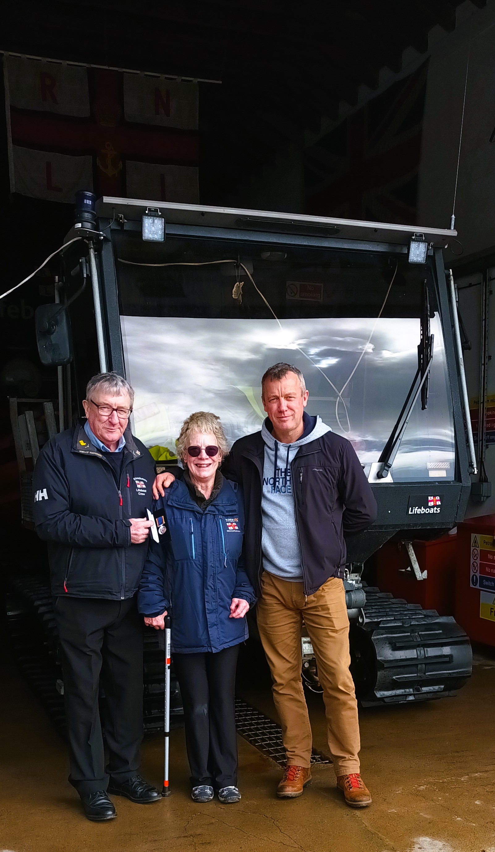 George Craig stood with his wife and son in front of lifeboat tractor