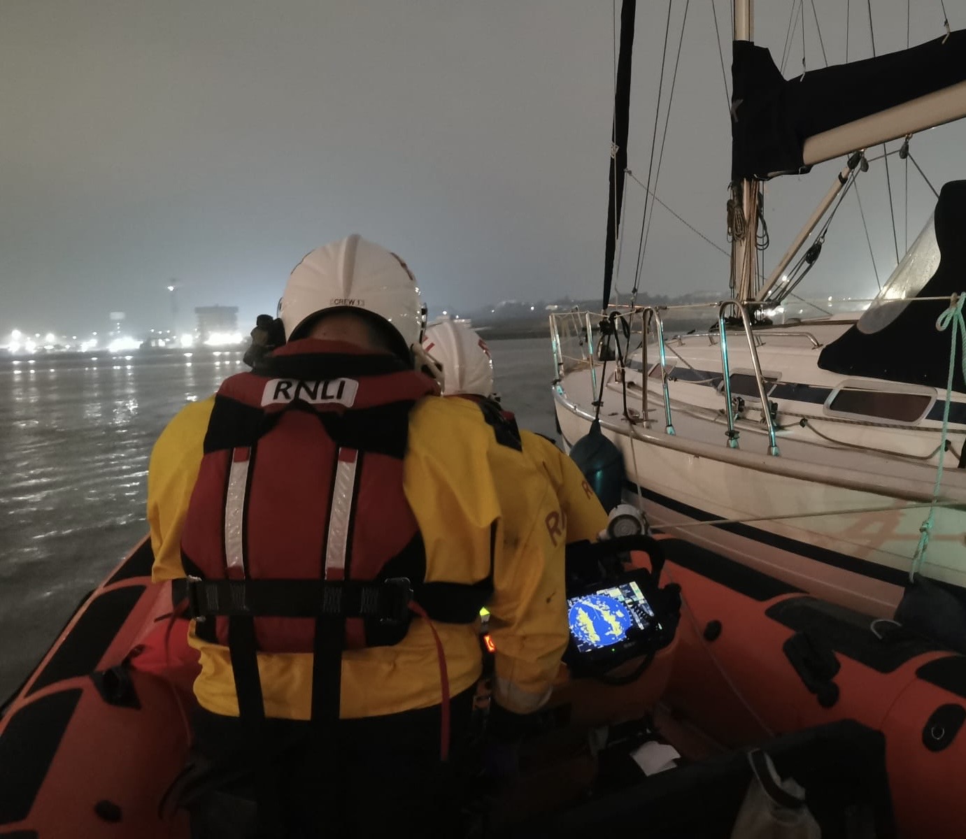 Gravesend Lifeboat crew on their vessel towing vessel on River Thames