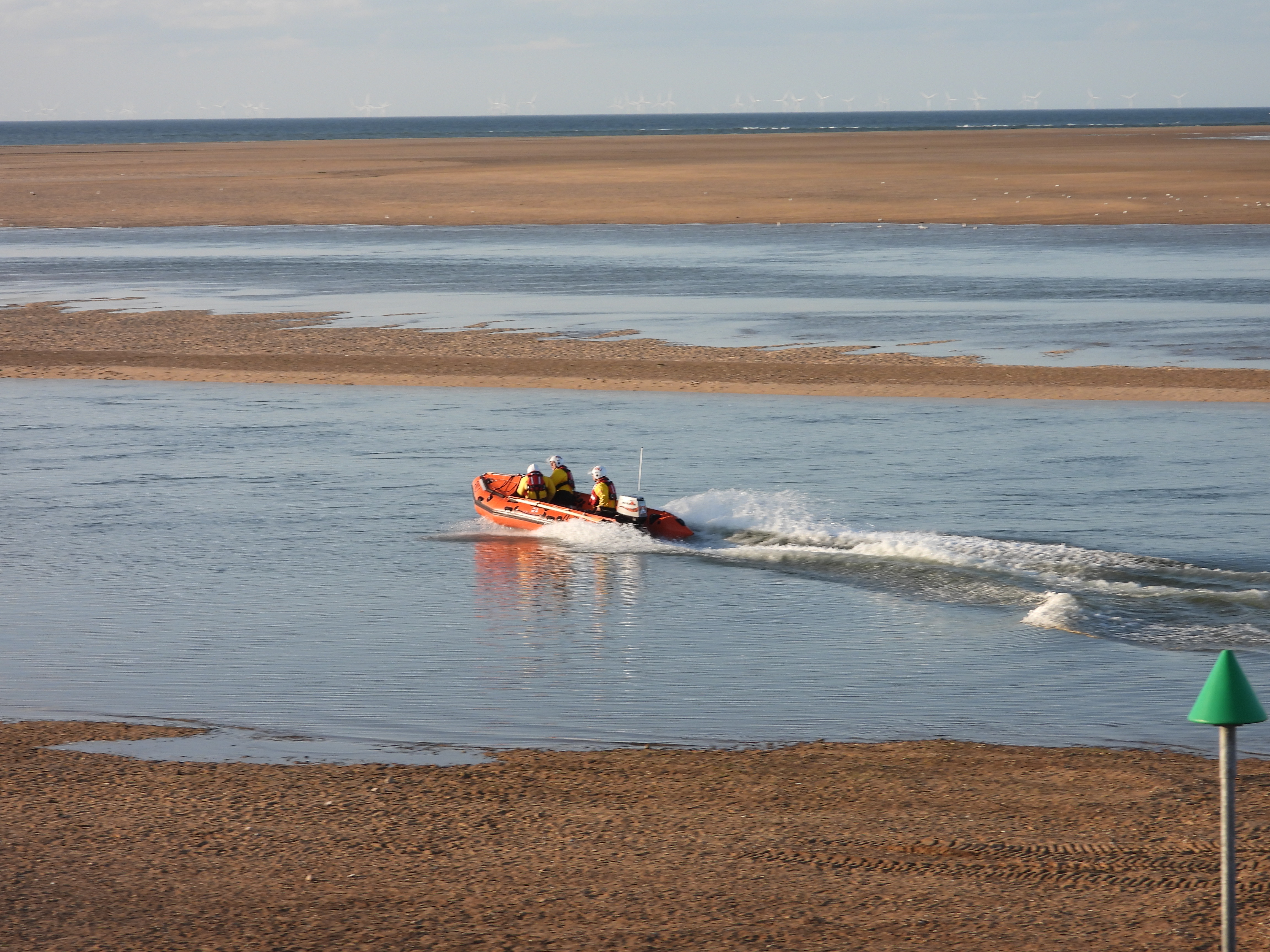 D-Class Inshore lifeboat in the water with 3 RNLI crew onboard