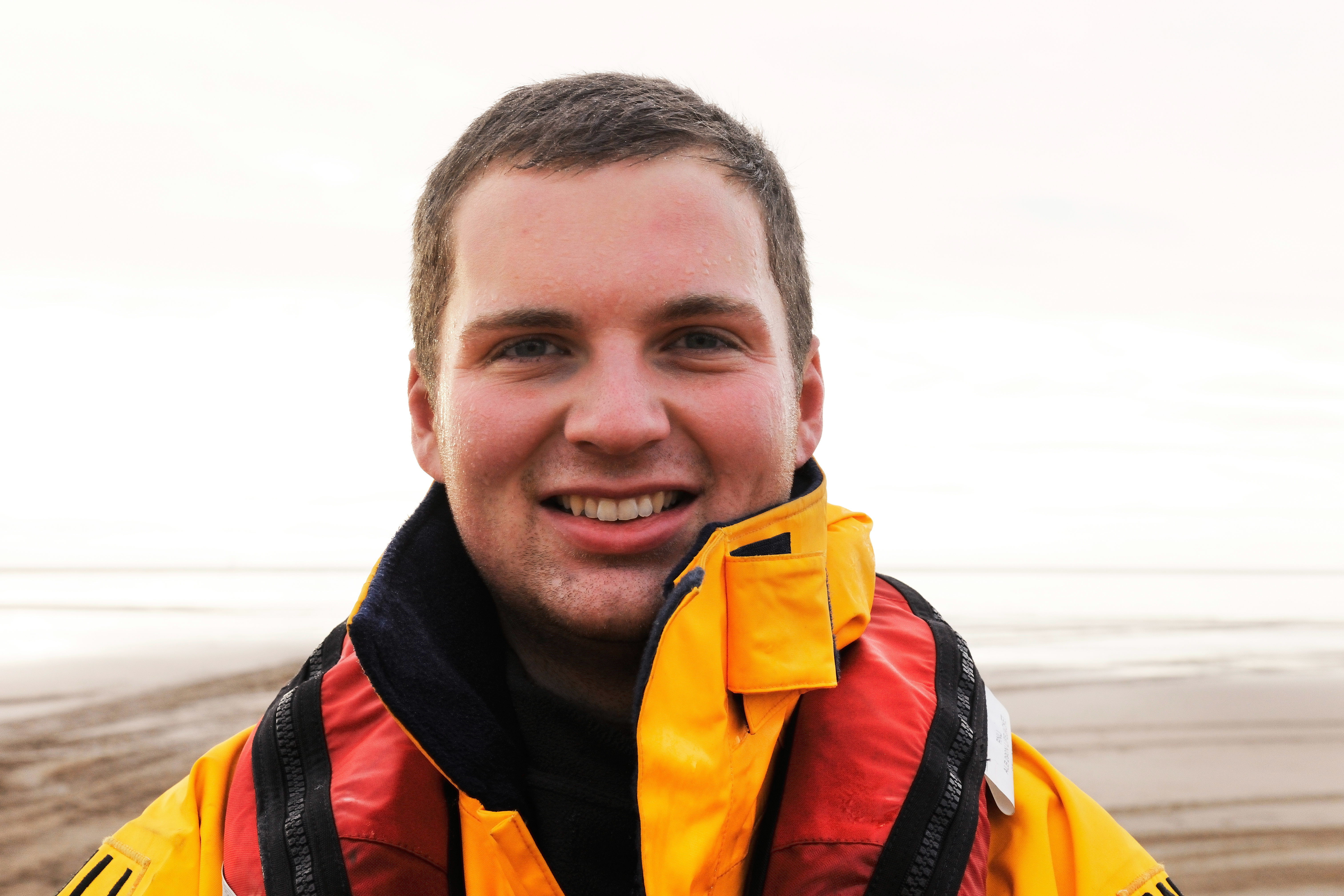 A Crew member with his RNLI lifejacket on smiles at the camera