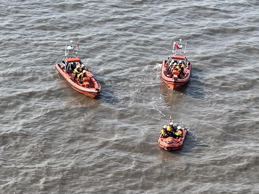 Three boats are waiting in the choppy waters of the estuary