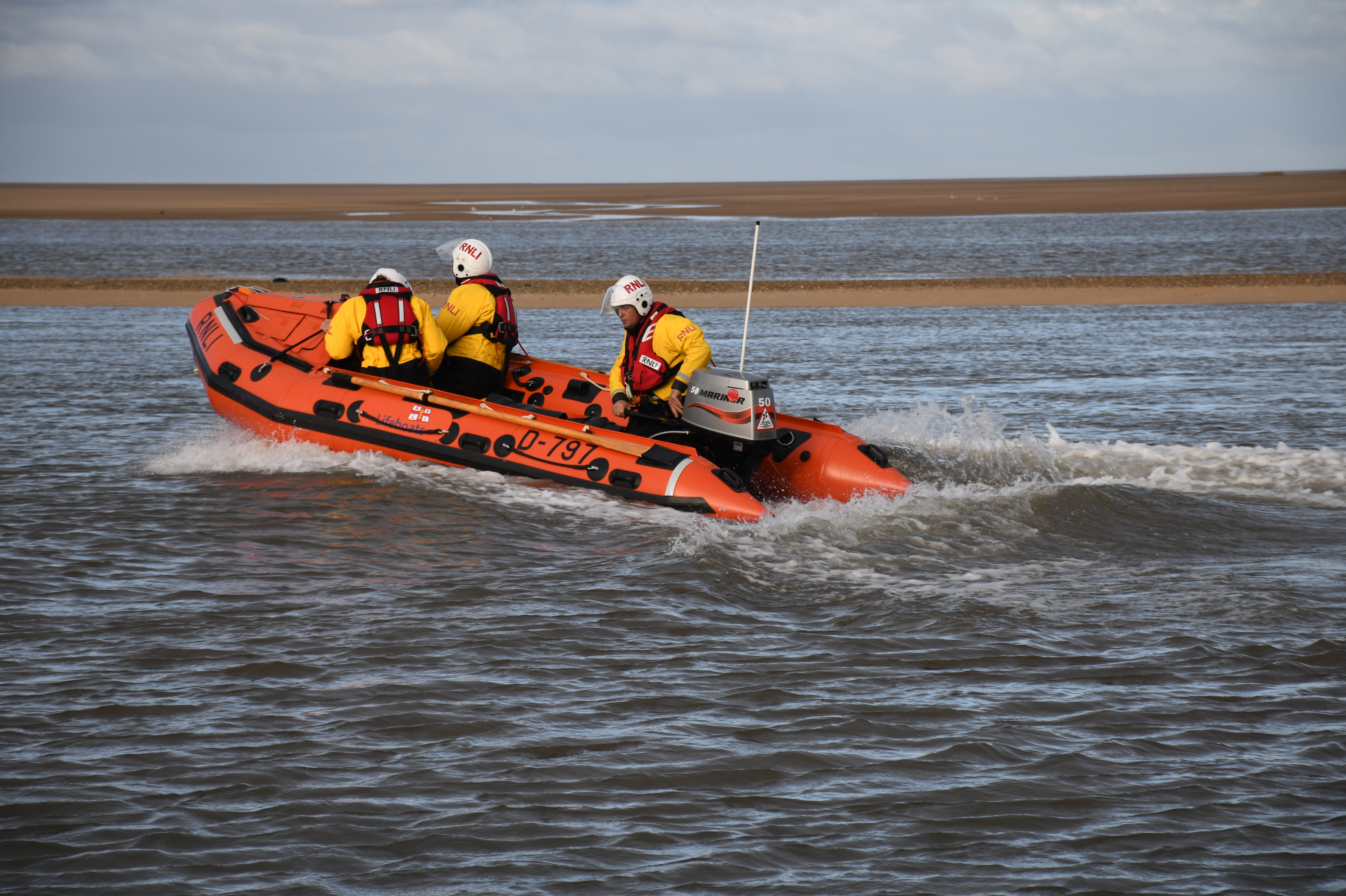 D-Class lifeboat in the sea with 3 volunteer crew 