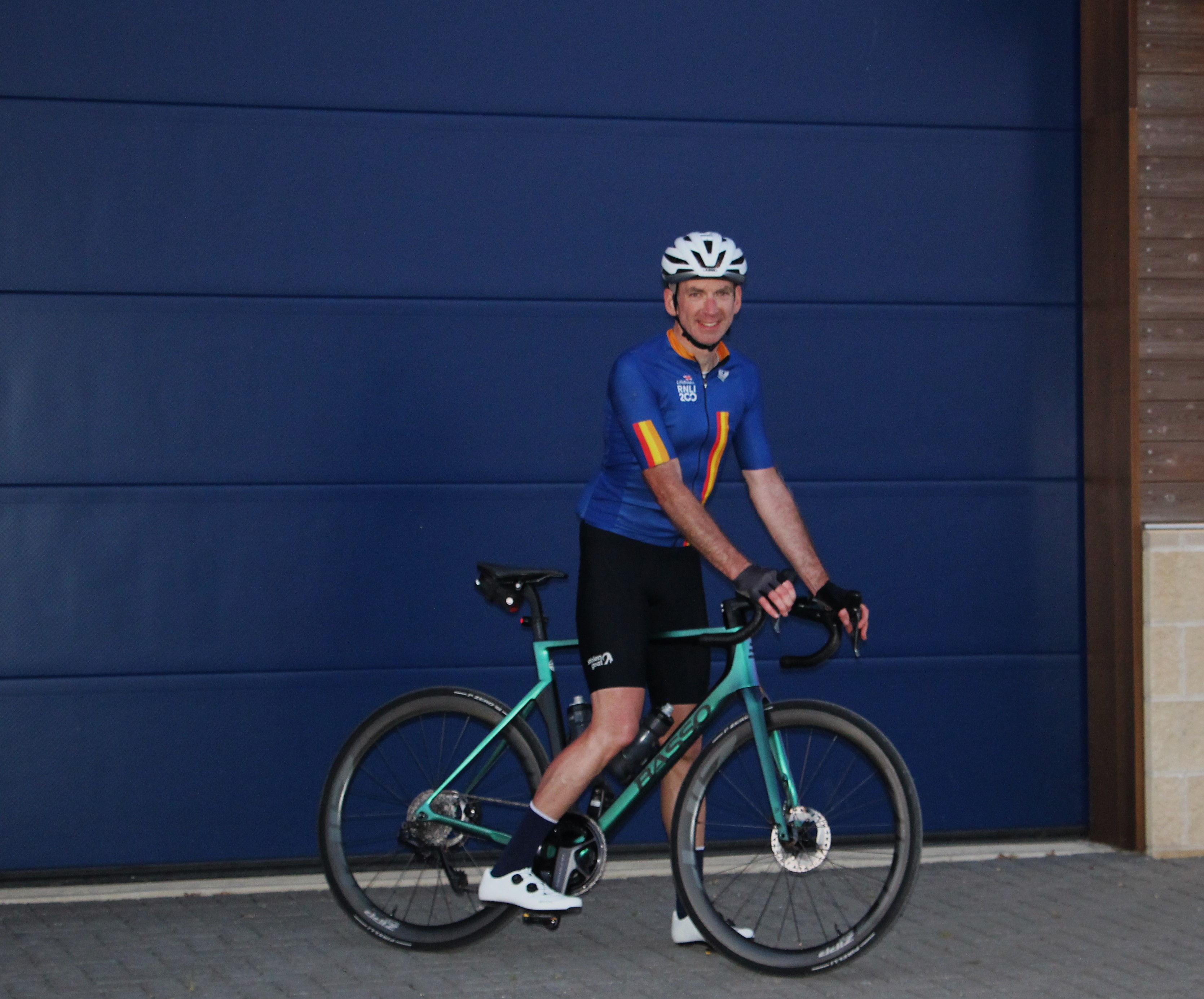 Paul Edwards with bike in front of a blue door at Wells RNLI