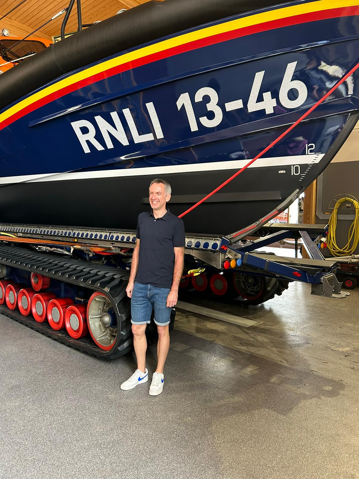 Paul Edwards standing in front of a Shannon class ALB lifeboat 