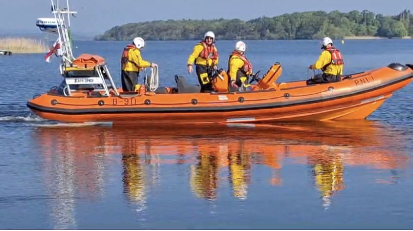 Lough Derg RNLI lifeboat, side on view with 4 crew on board, setting off from Lough Derg Yacht Club
