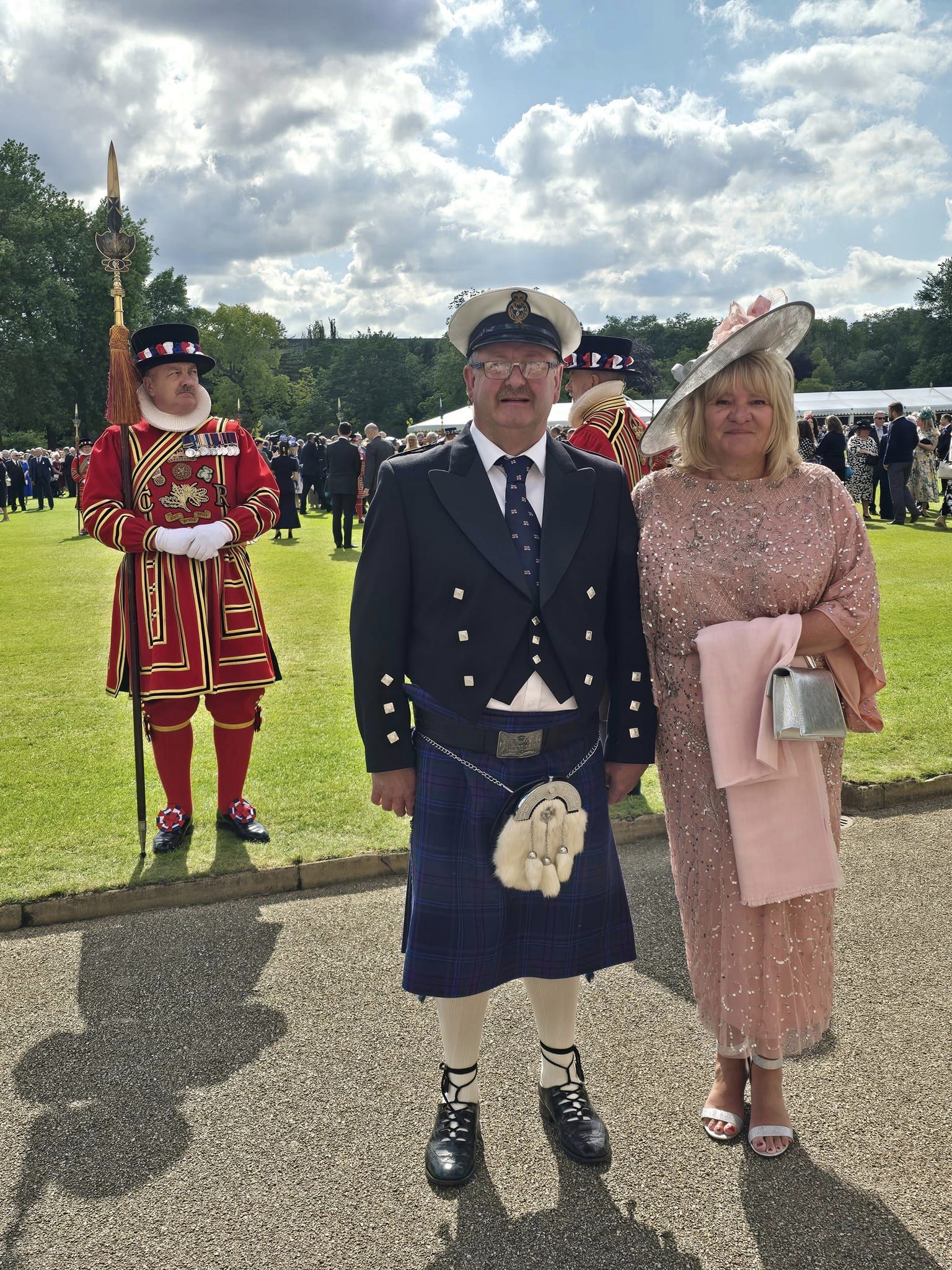 Christopher 'Jeeky' and Lillian Norris attend the RNLI 200th anniversary garden party at Buckingham Palace. They are pictured in the grounds near a Beefeater guard.