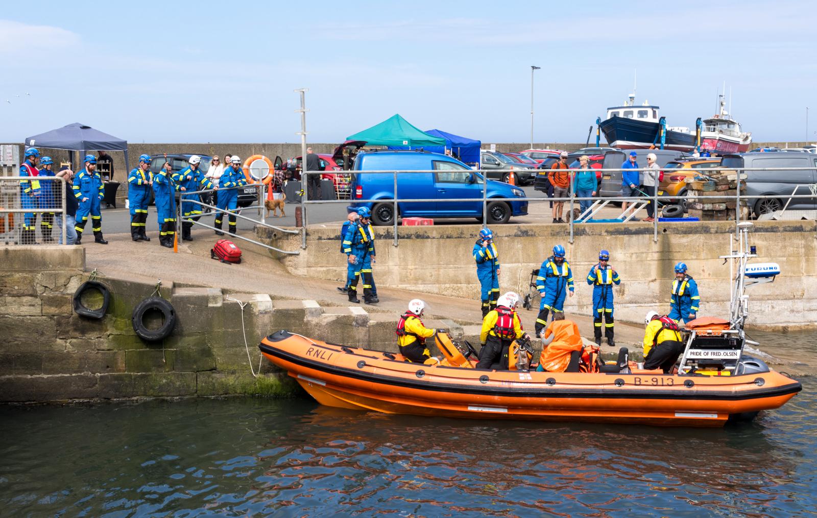 Berwick-upon-Tweed RNLI returning to Seahouses Harbour with rescued paddle boarder, handing over to awaiting H M Coastguard