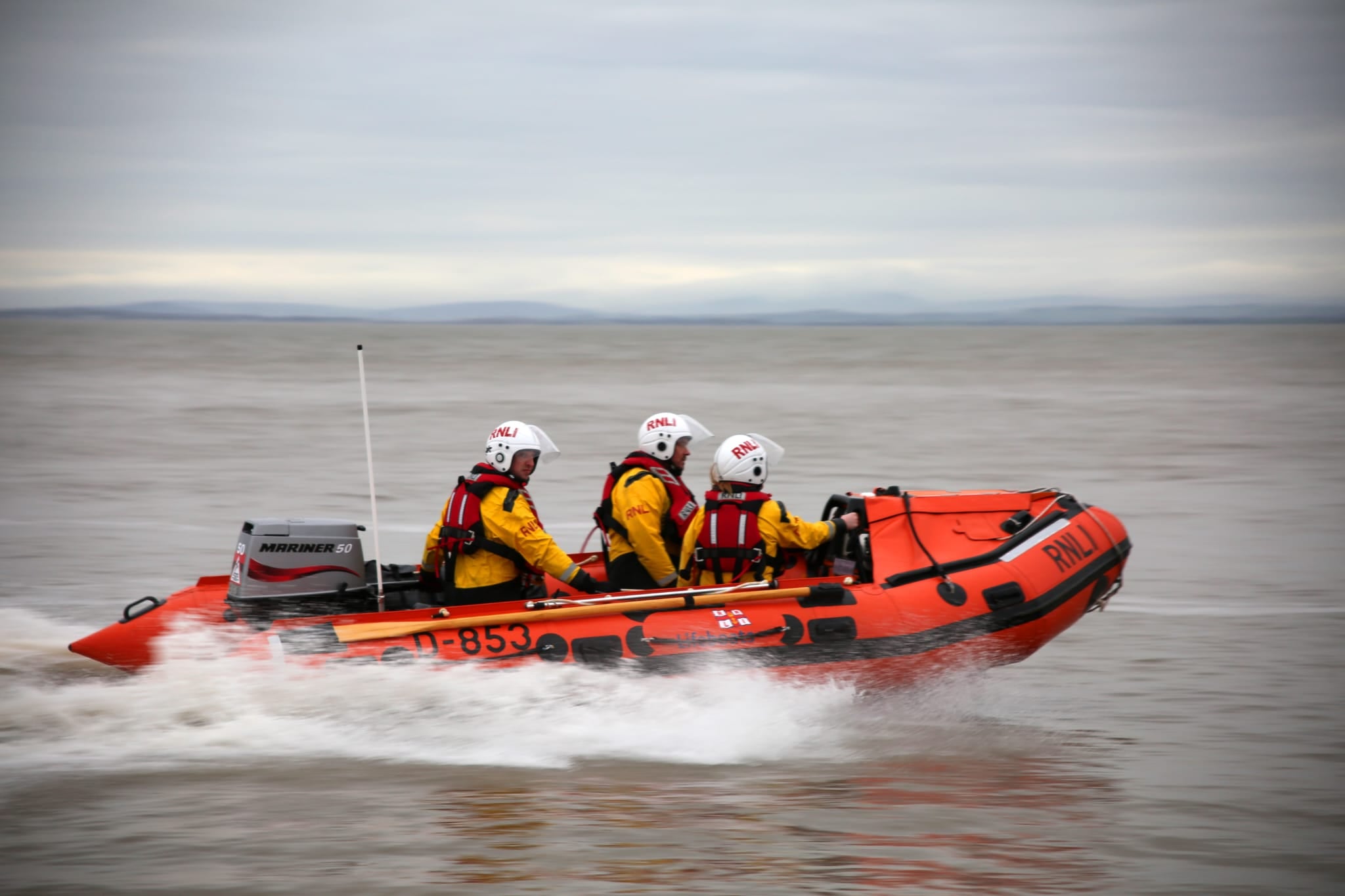 RNLI Inshore Lifeboat D-853 Harbet making way, with spray emanating from about halfway along the hull
