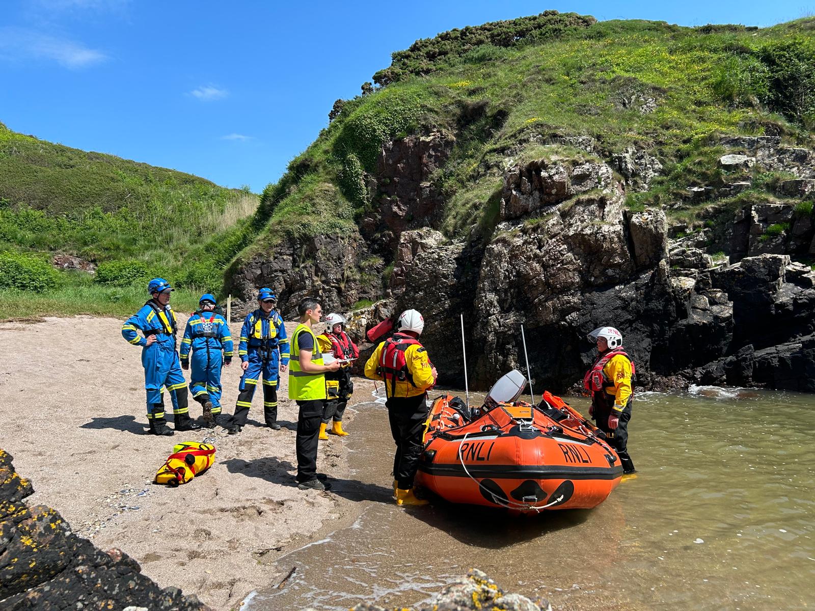 Photo shows D-854 with lifeboat crew and coastguard teams on the shore line