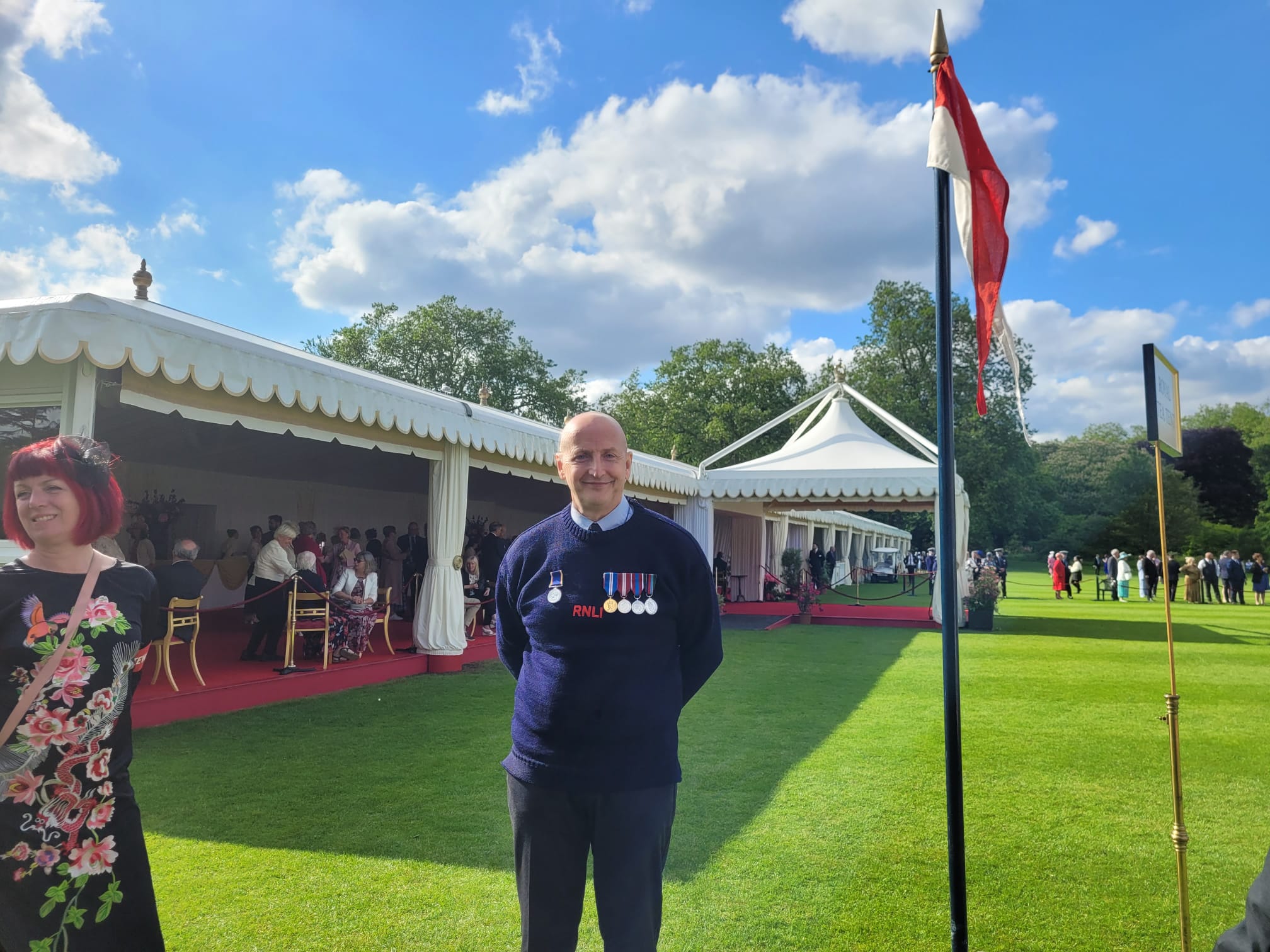 New Brighton RNLI crew member Andy Liston poses in RNLI guernsey and medals on the lawn at Buckingham Palace.