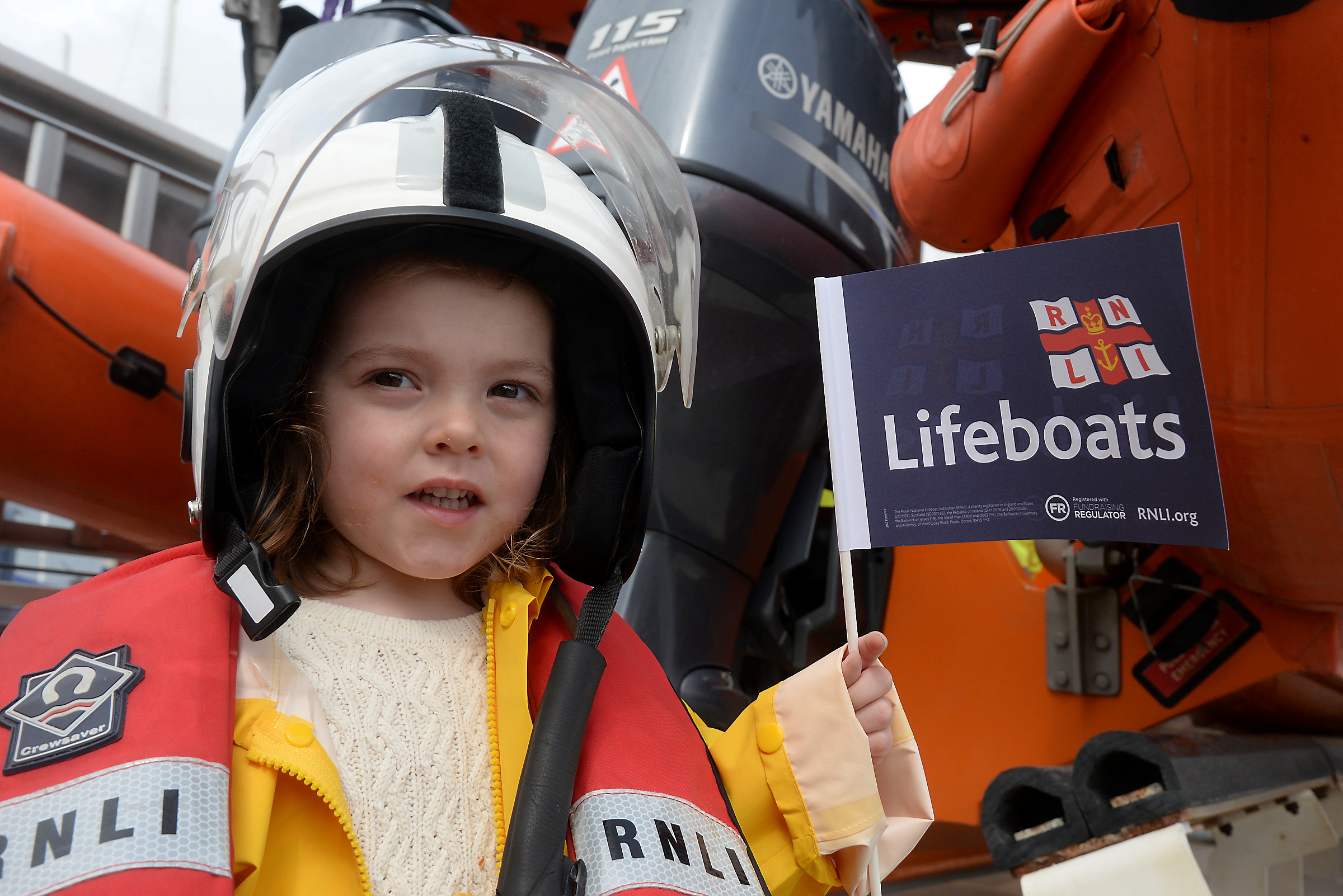 Isla Brannan, two waves the flag for the RNLI during the open day at Whitstable lifeboat station on bank holiday Monday
