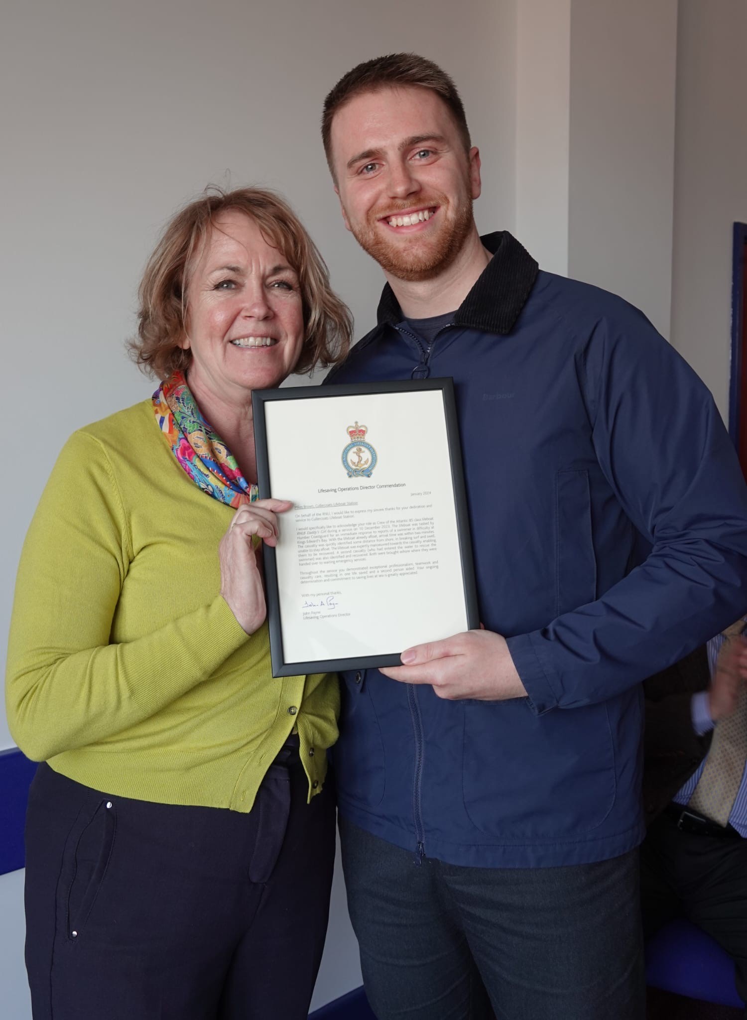 Jayne hands Miles a certificate of commendation 