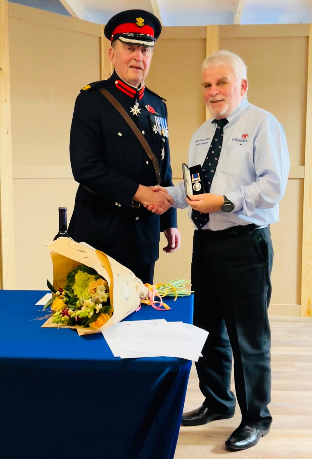 The photo shows Brendan Pitt receiving his long service medal 