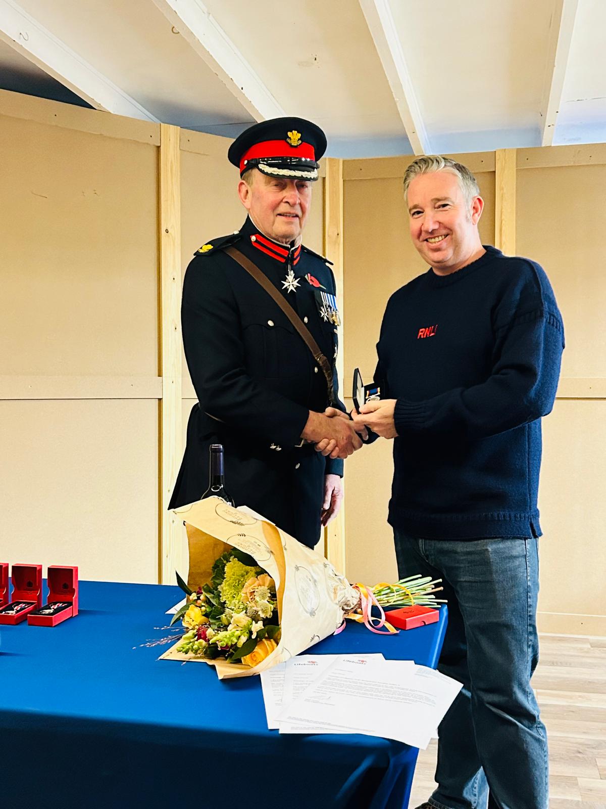 The photo shows Josh Brown receiving his long service medal 