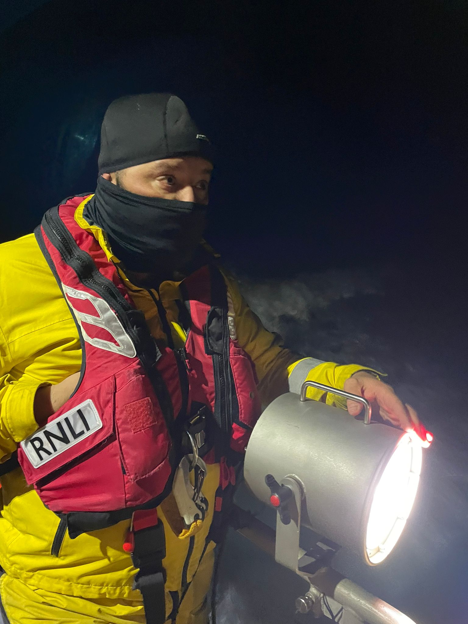 Crew members looking for debris etc with searchlights in use.