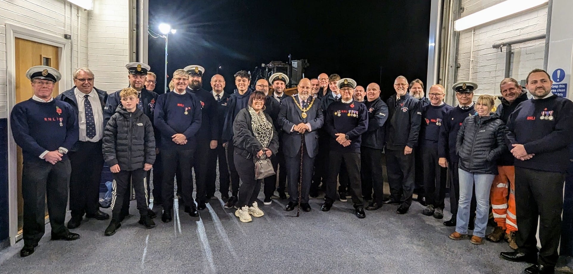 RNLI volunteers and families infront of the RNLI tractor and lifeboat with Lord Warden Admiral Sir George Zambellas and The Right Worshipful the Mayor of New Romney CllrJohn Rivers after receiving their King's Coronation Medals