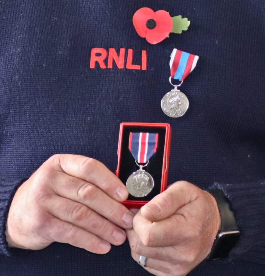 The King’s Coronation Medal in presentation box being held by an RNLI volunteer recipient.