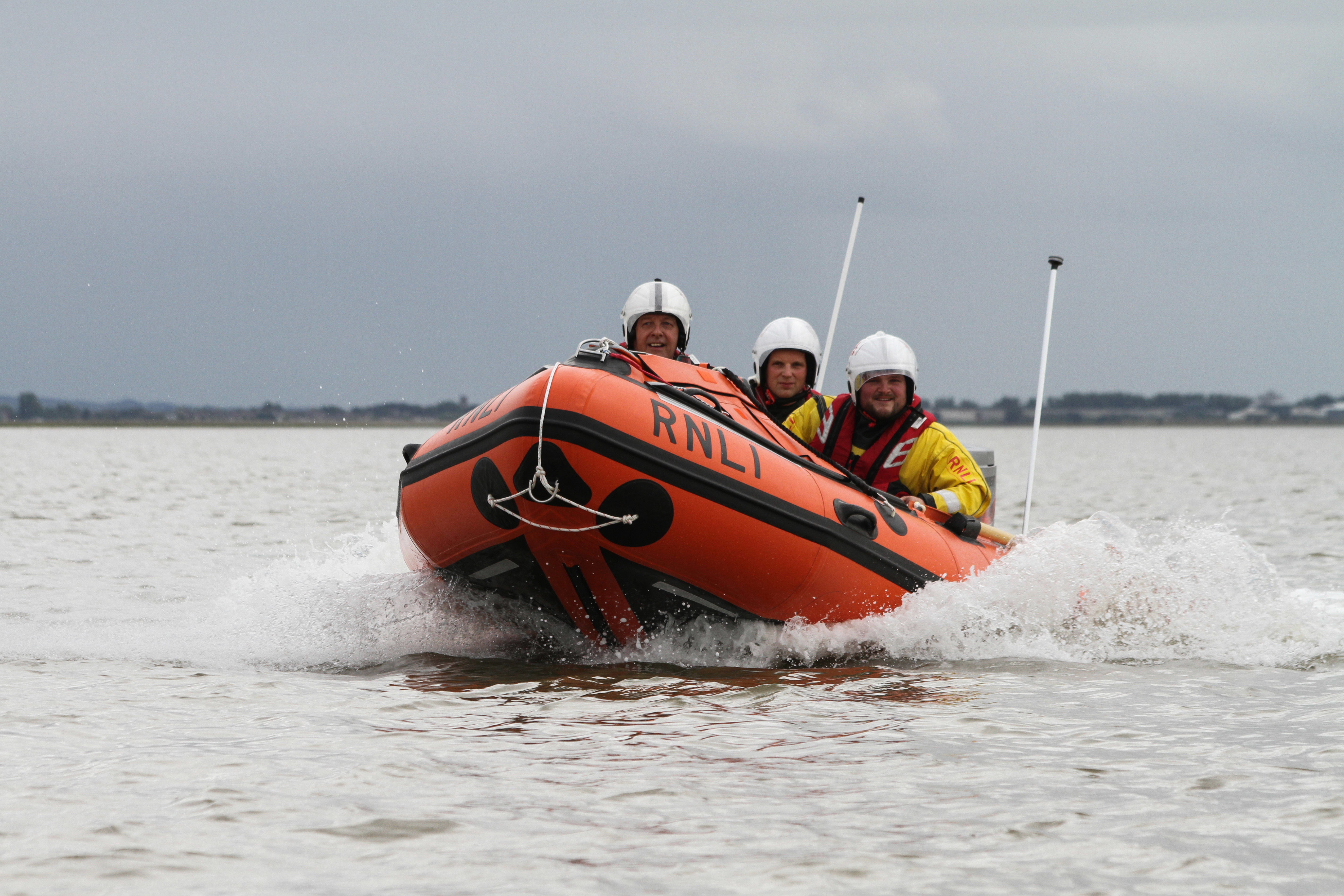 An Inshore Lifeboat (ILB) with three crew on board heads towards the camera