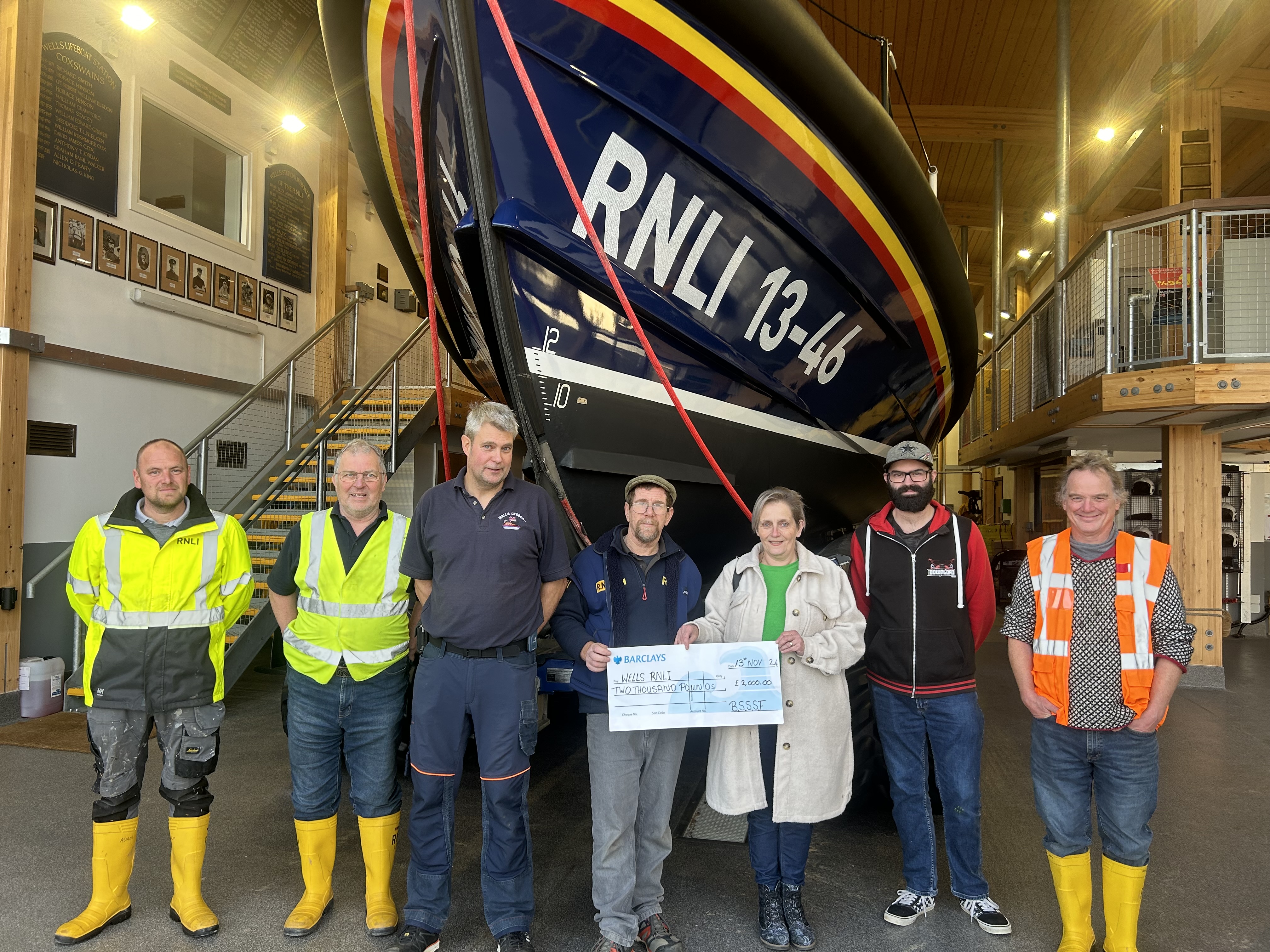 Sam Ireson and Sue Ireson present Wells RNLI with Cheque from Brancaster Sea Shanty Festival With members of Wells RNLI infront of Shannon class lifeboat ‘ Duke of Edinburgh’