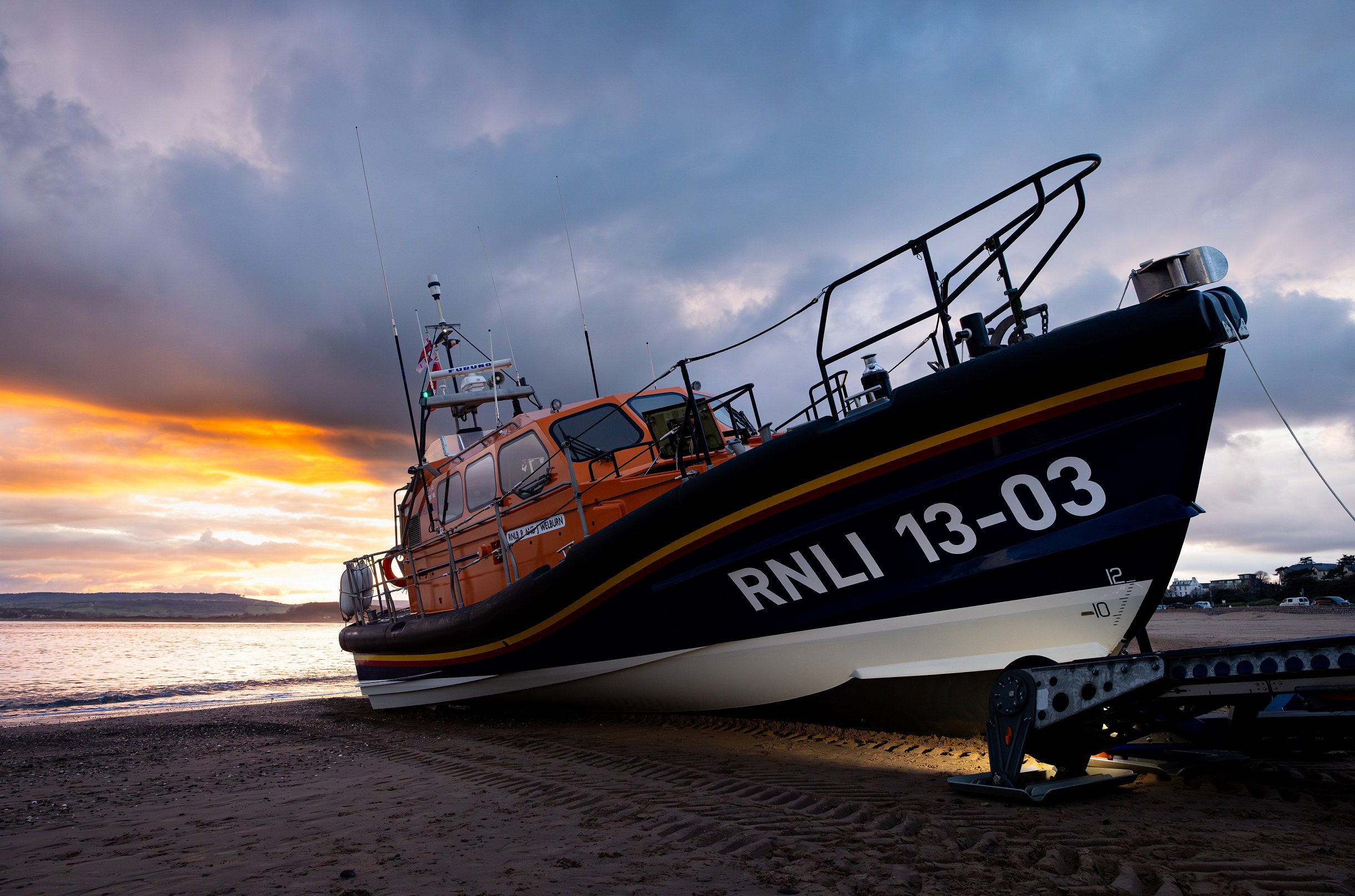 A Shannon class lifeboat in front of a colourful sunset