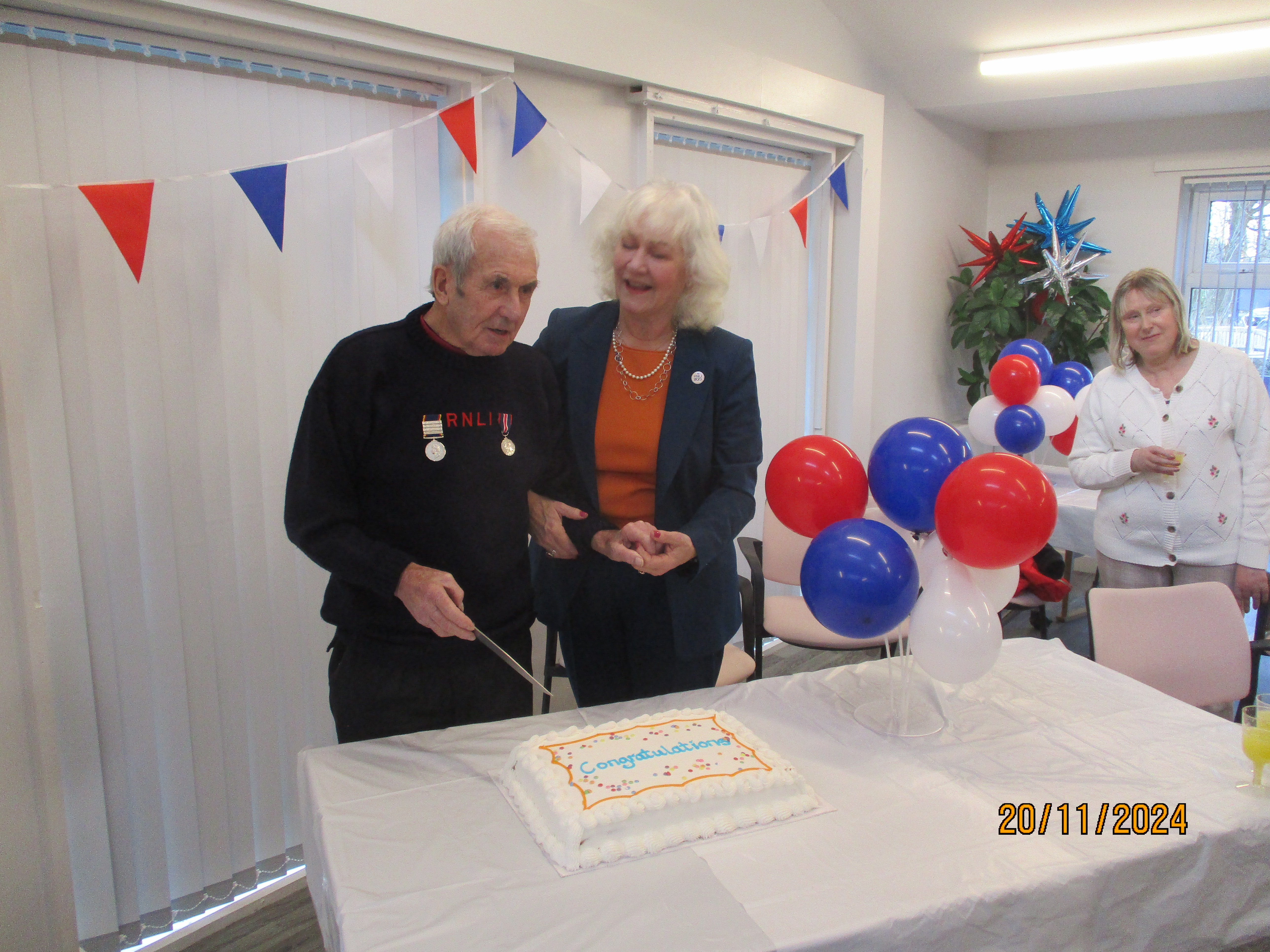 Tim (left) accompanied by His Majesty’s Lord-Lieutenant, Dr Caroline Pryer celebration cake cutting