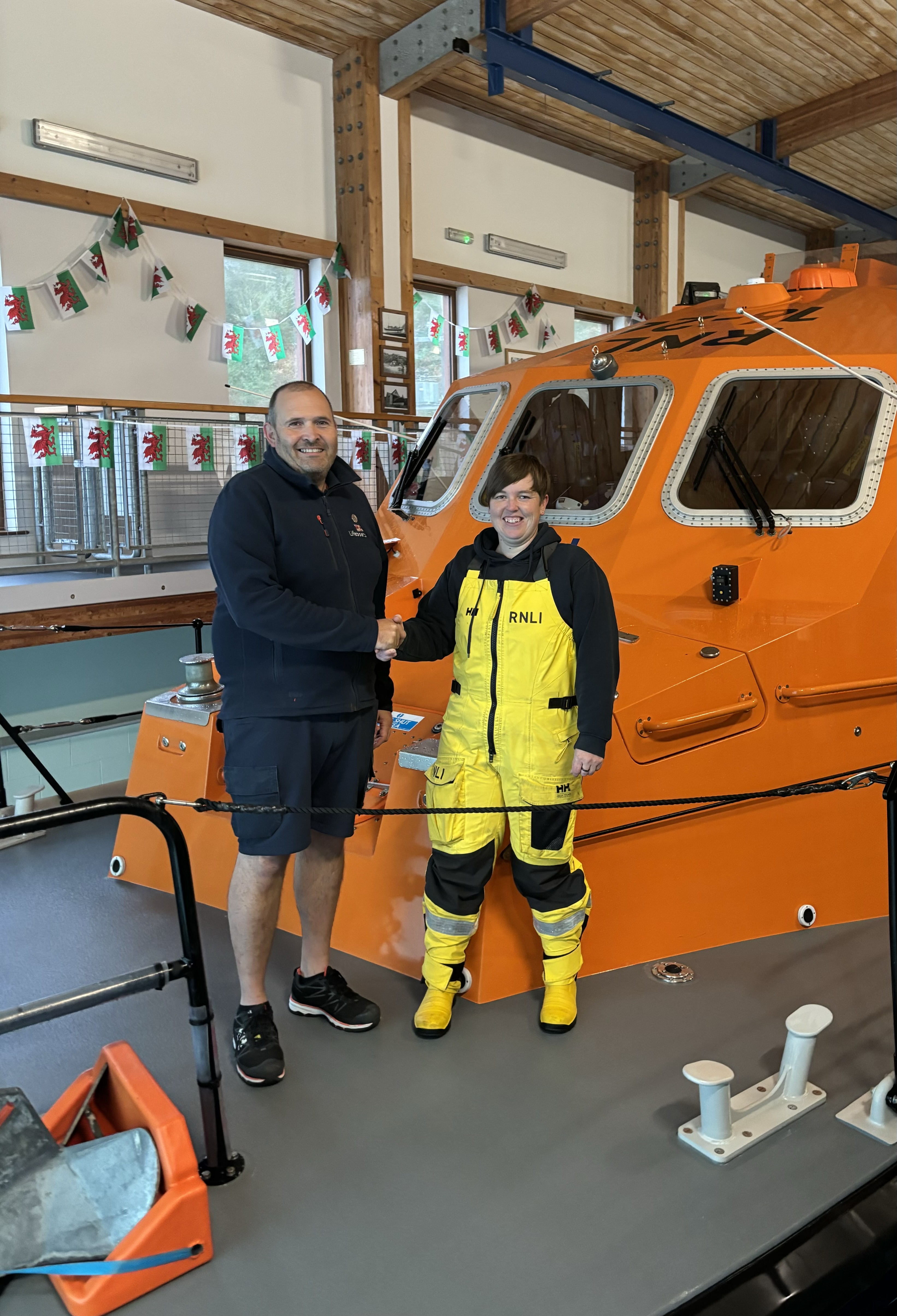 aryl Thomas of Porthdinllaen being congratulated by RNLI Assessor Hugh 'Spud' Davies