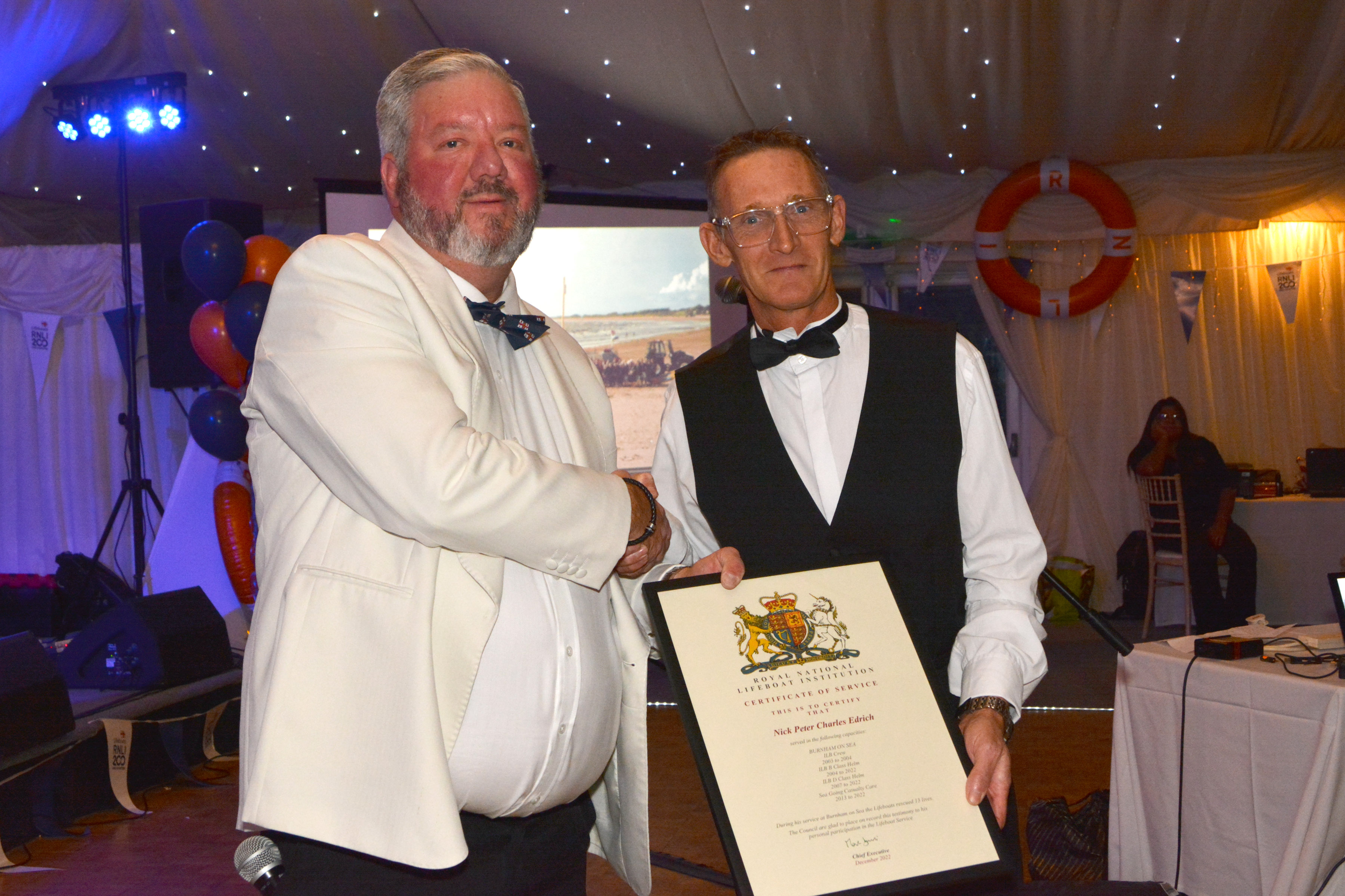 Lifeboat Operations Manager Matt Davies presents the certificate of thanks to Nick Edrich