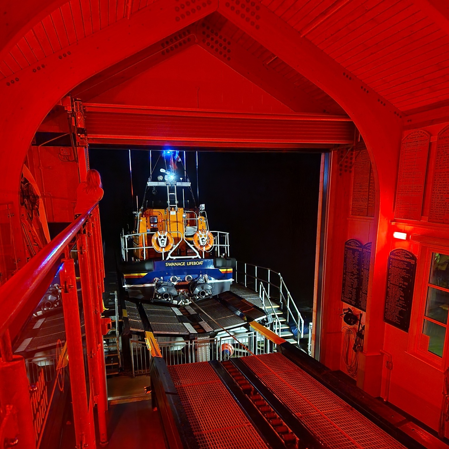 Swanage Lifeboat Station at night with the all-weather lifeboat being recovered up the slipway.