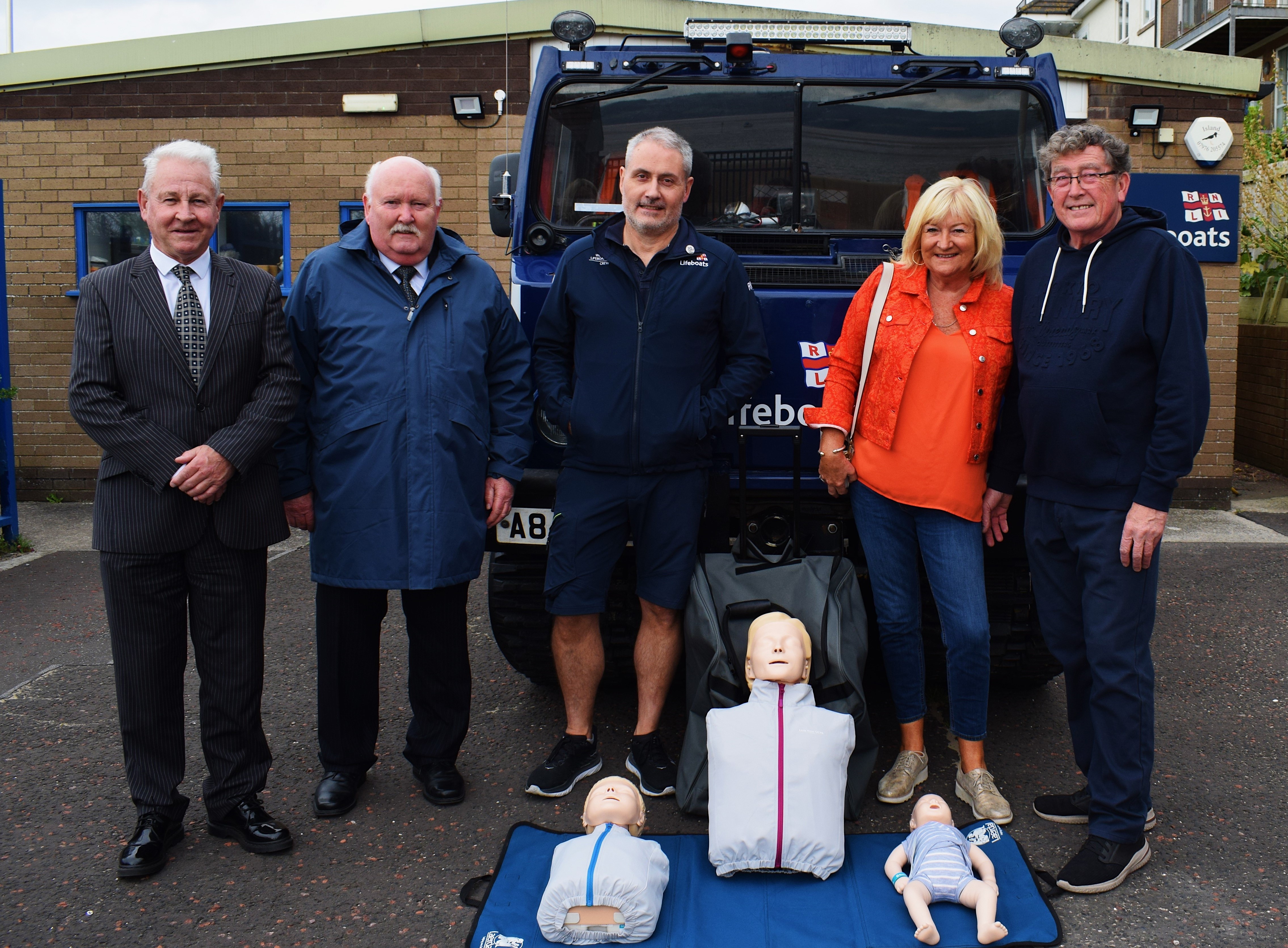 Individuals stood in front of the BV launch vehicle outside the station with the CPR family set in front of them