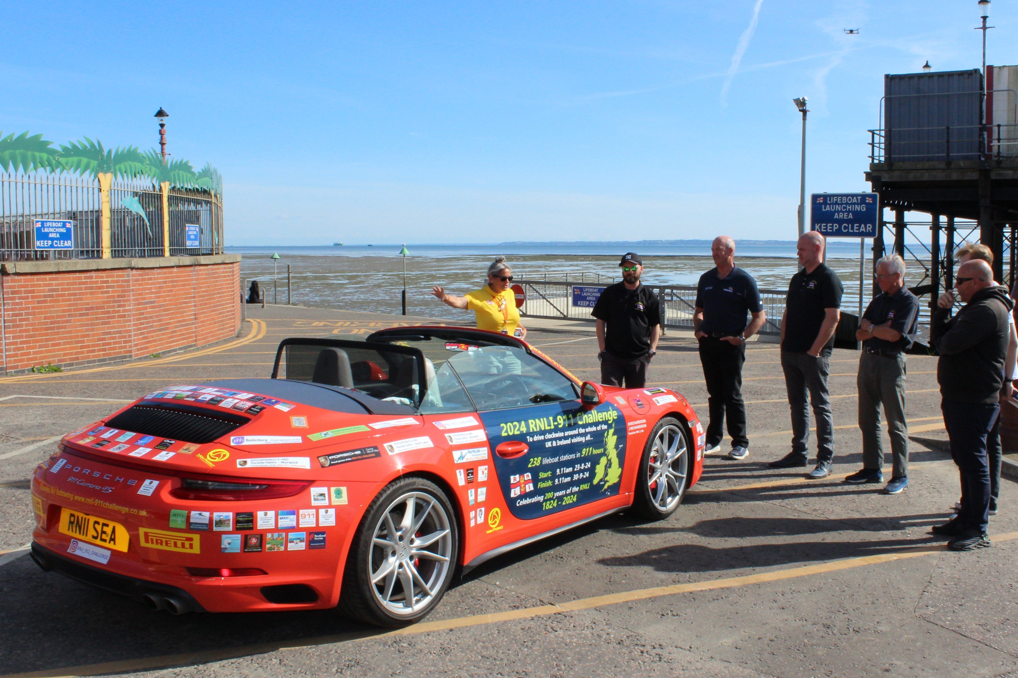 Belinda talking to Southend volunteers in front of Porsche 911