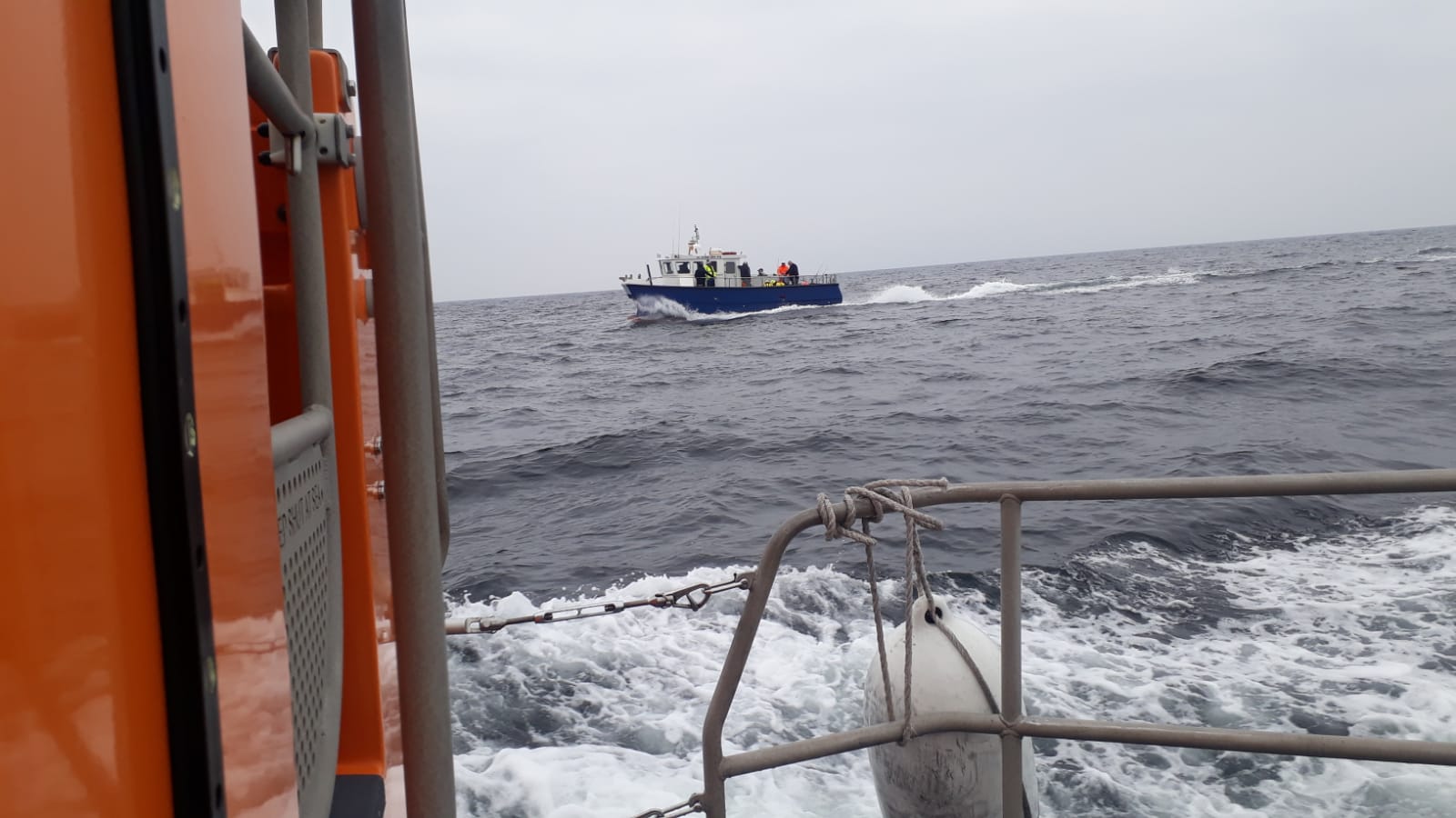 Eyemouth lifeboat crew assist injured angler on fishing trip, view is from the lifeboat looking across to the fishing boat where lifeboat crew gave first aid casualty care.