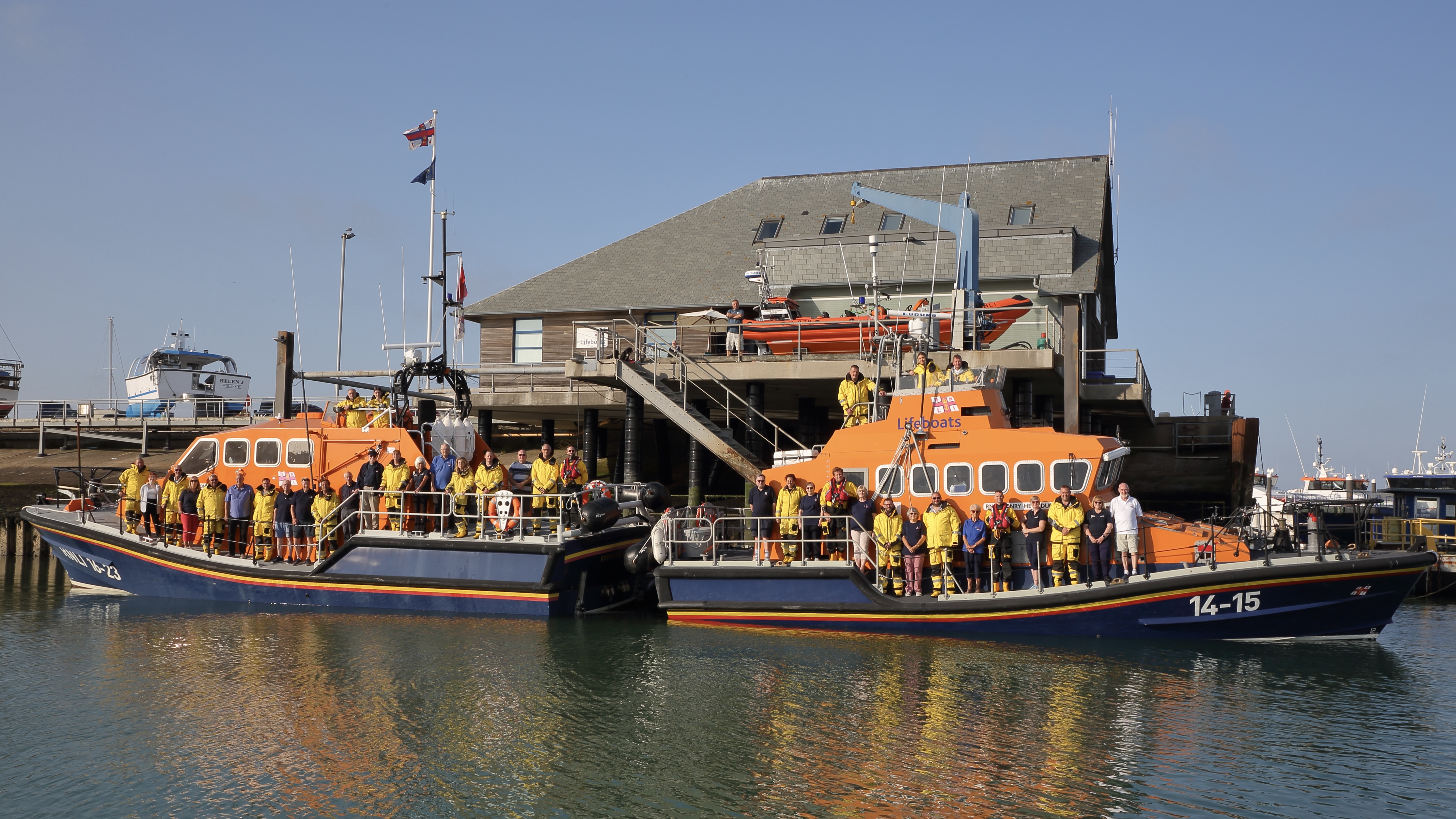 Two lifeboats back to back with crew onboard