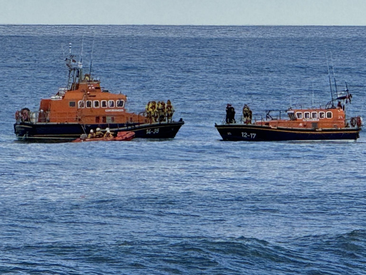 Three orange boats on water.