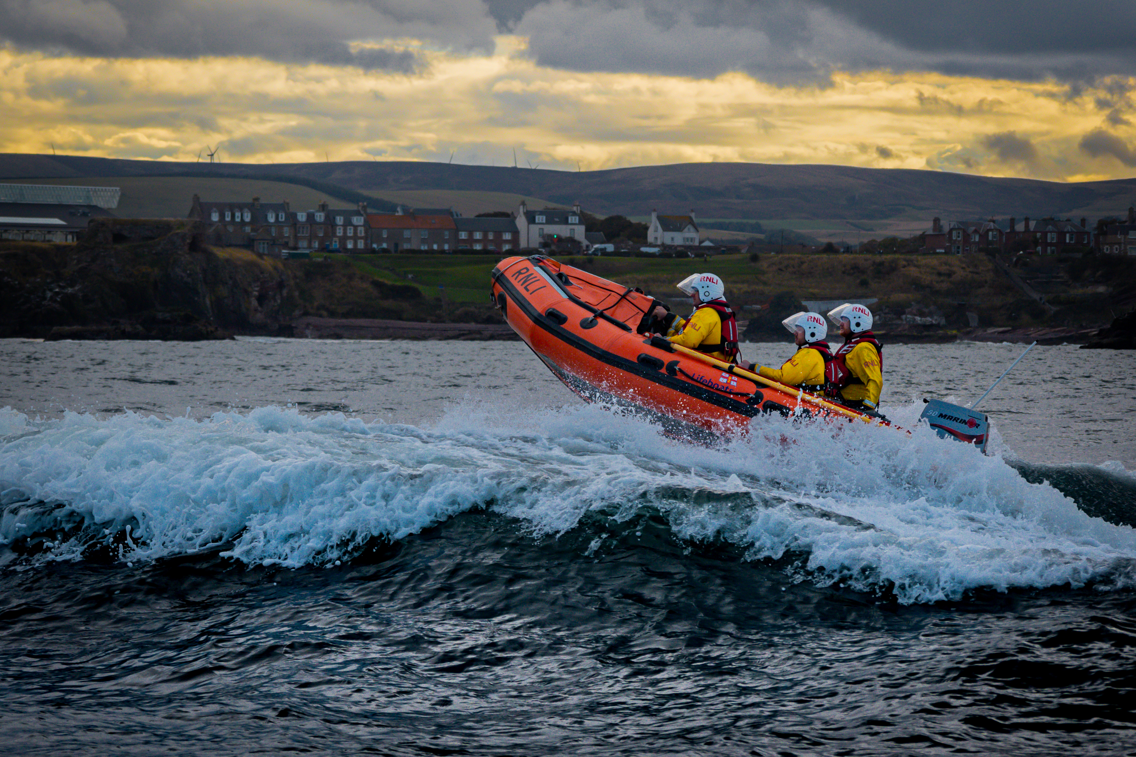 Rigid inflatable lifeboat on water.