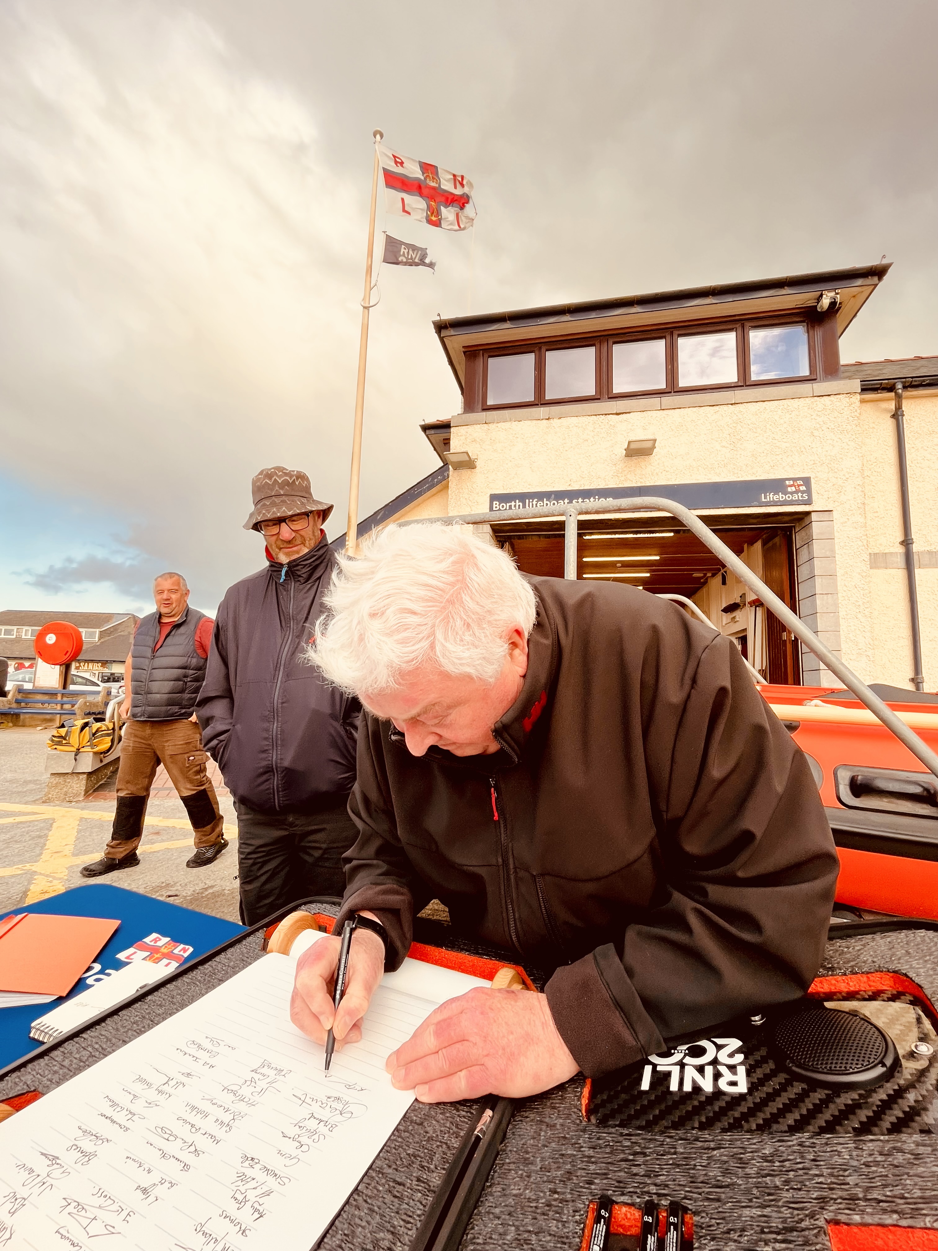 Borth RNLI Ron Davies MBE signs the RNLI 200 scroll