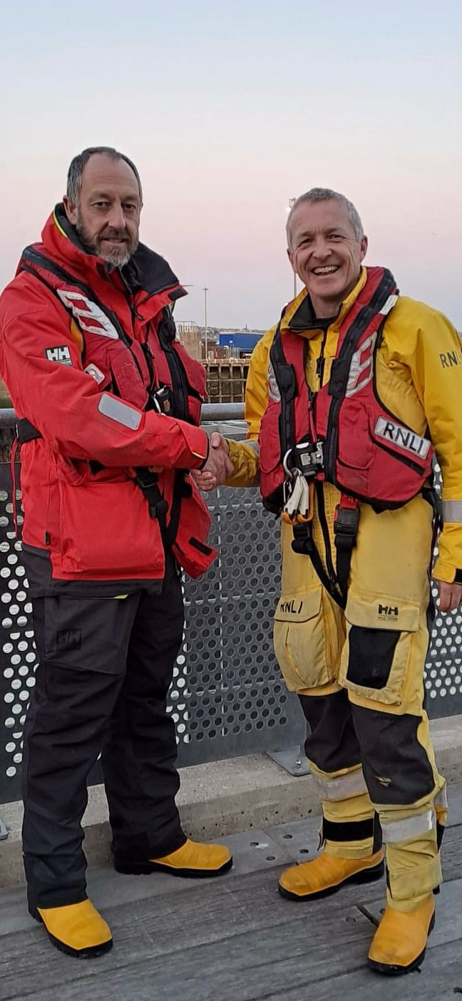 Assessor Dave Needham shaking John Simcock's hand