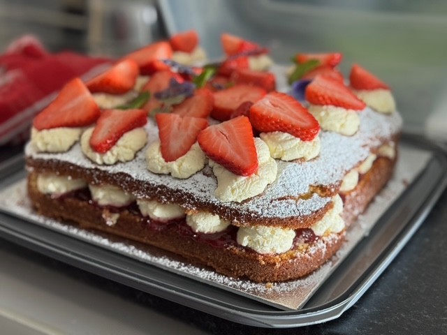 Jean Fowlers 75 years of volunteering celebration cake made by RNLI Blyth. Cream cake with strawberries on top
