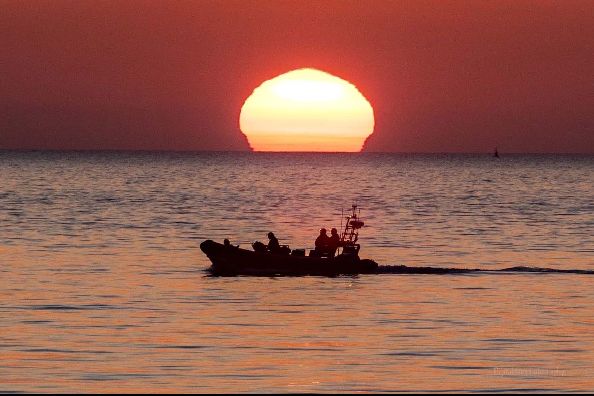 Port Erin Atlantic 85 inshore lifeboat at sea, sunset in the distance